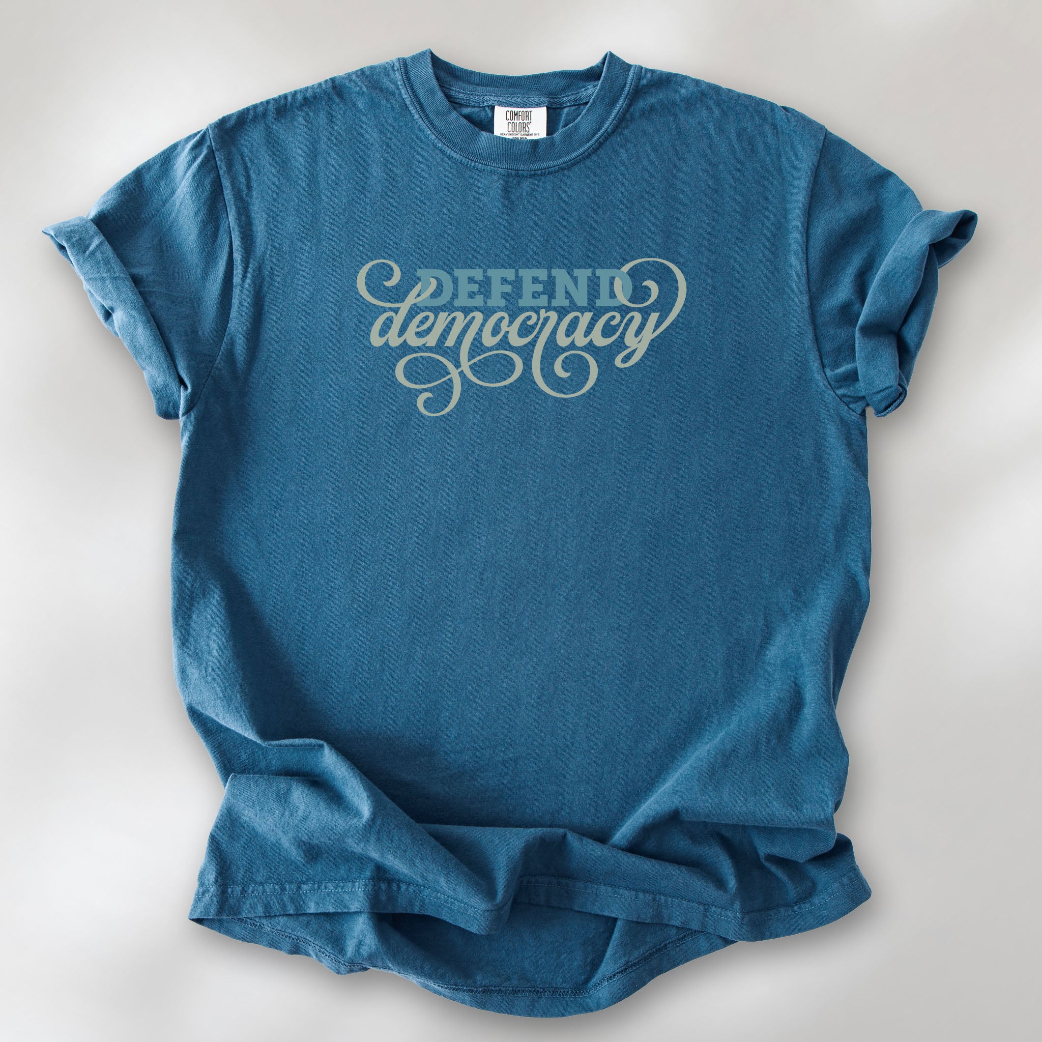 Midnight t-shirt with blue and green script text reading “Defend Democracy.”