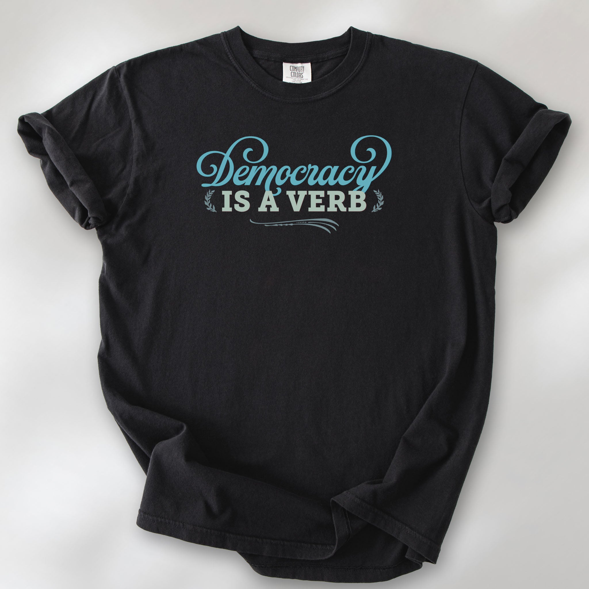 Black t-shirt with the phrase “Democracy Is a Verb” in decorative lettering.