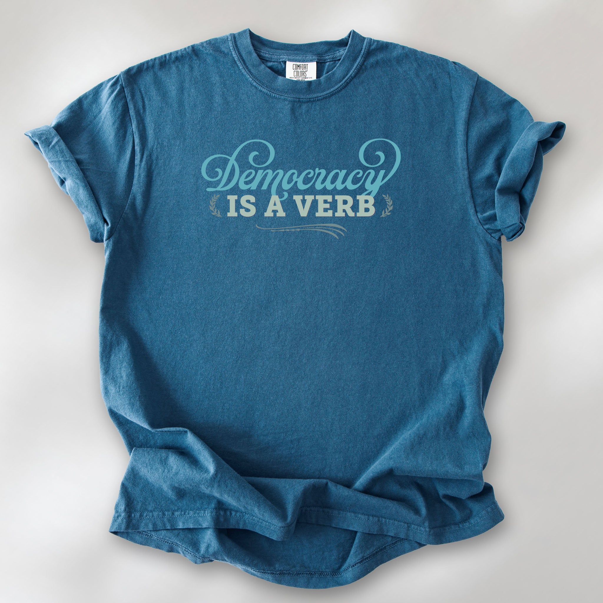 Midnight t-shirt with the phrase “Democracy Is a Verb” in decorative lettering.