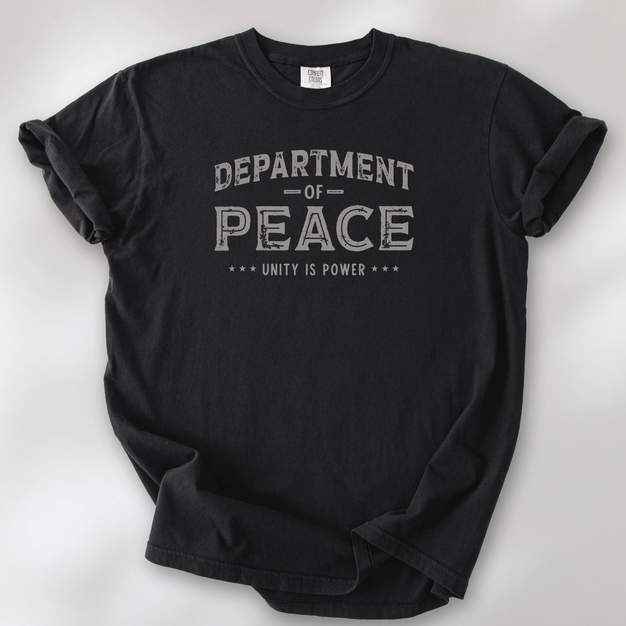 Black t-shirt with distressed text reading “Department of Peace — Unity is Power” in vintage style design.