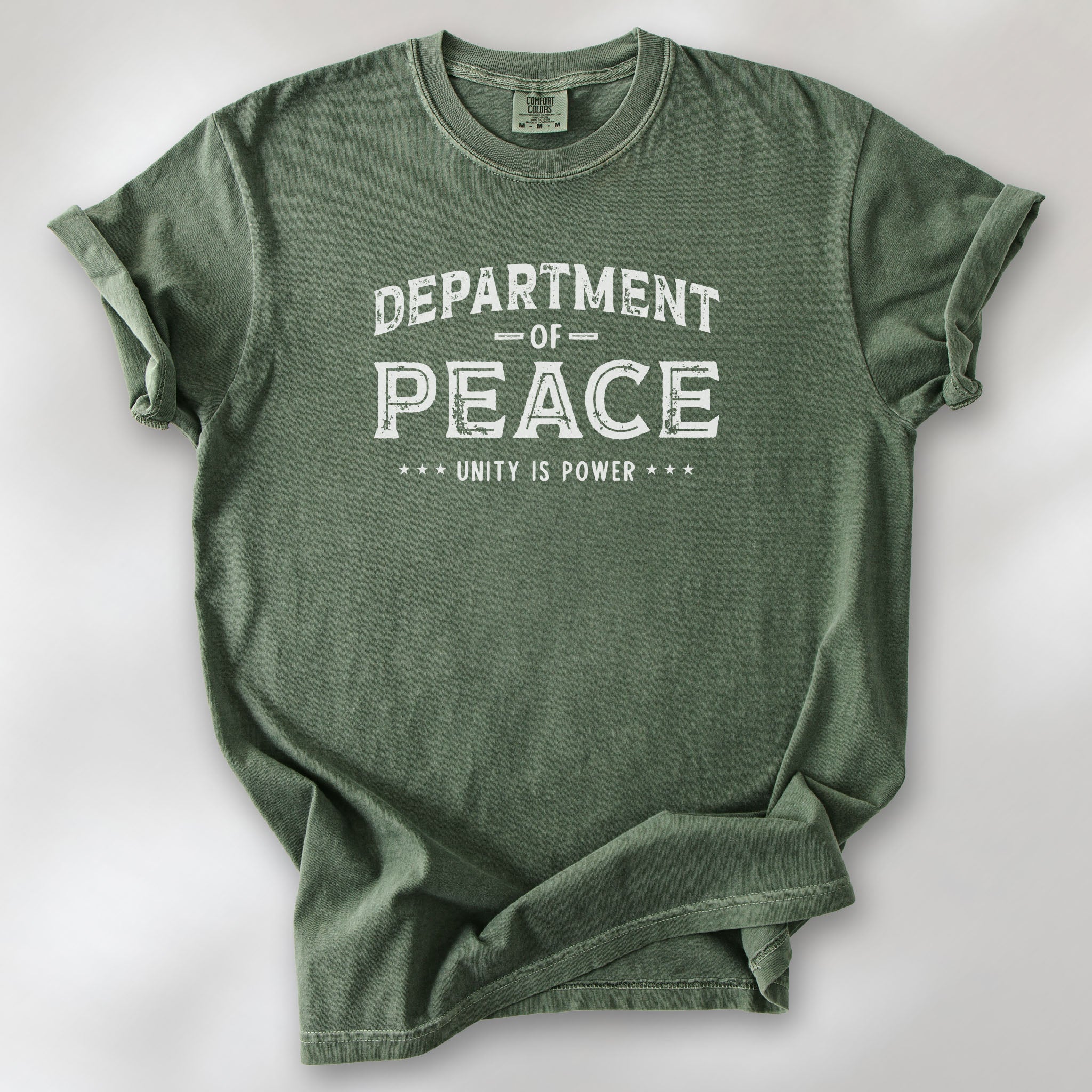Moss t-shirt with distressed text reading “Department of Peace — Unity is Power” in vintage style design.