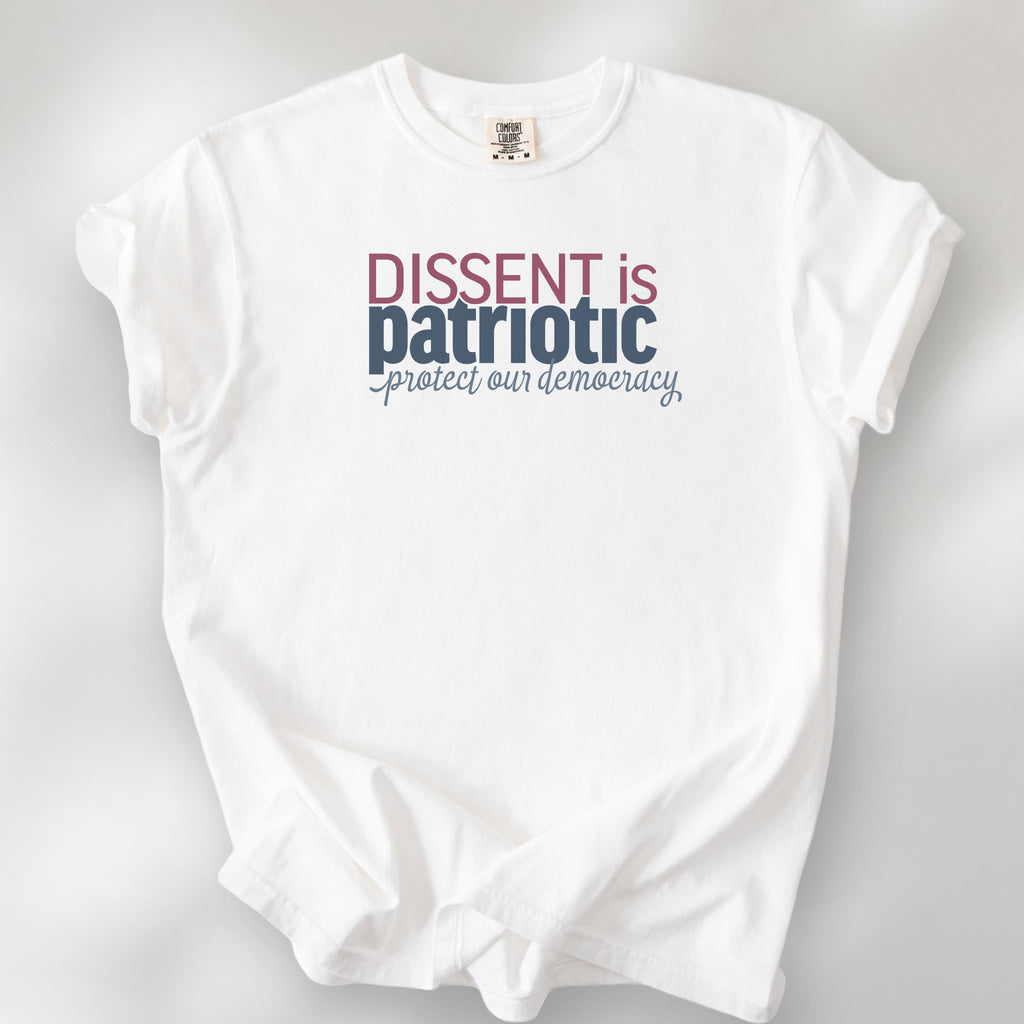 White unisex t-shirt with bold text reading “Dissent is Patriotic – Protect Our Democracy” in red, blue, and gray.