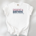 White unisex t-shirt with bold text reading “Dissent is Patriotic – Protect Our Democracy” in red, blue, and gray.
