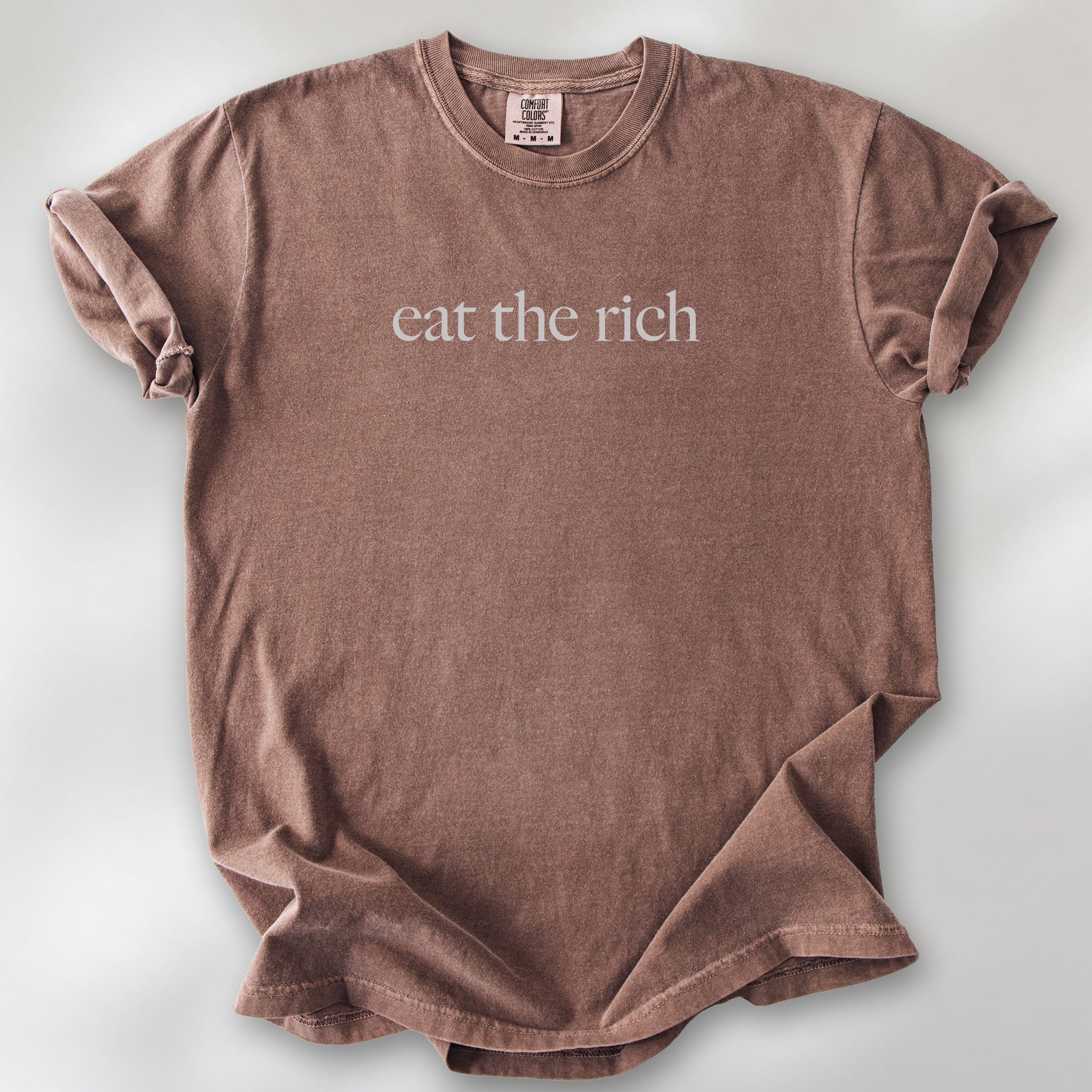 Espresso t-shirt with minimalist light grey text reading “eat the rich."