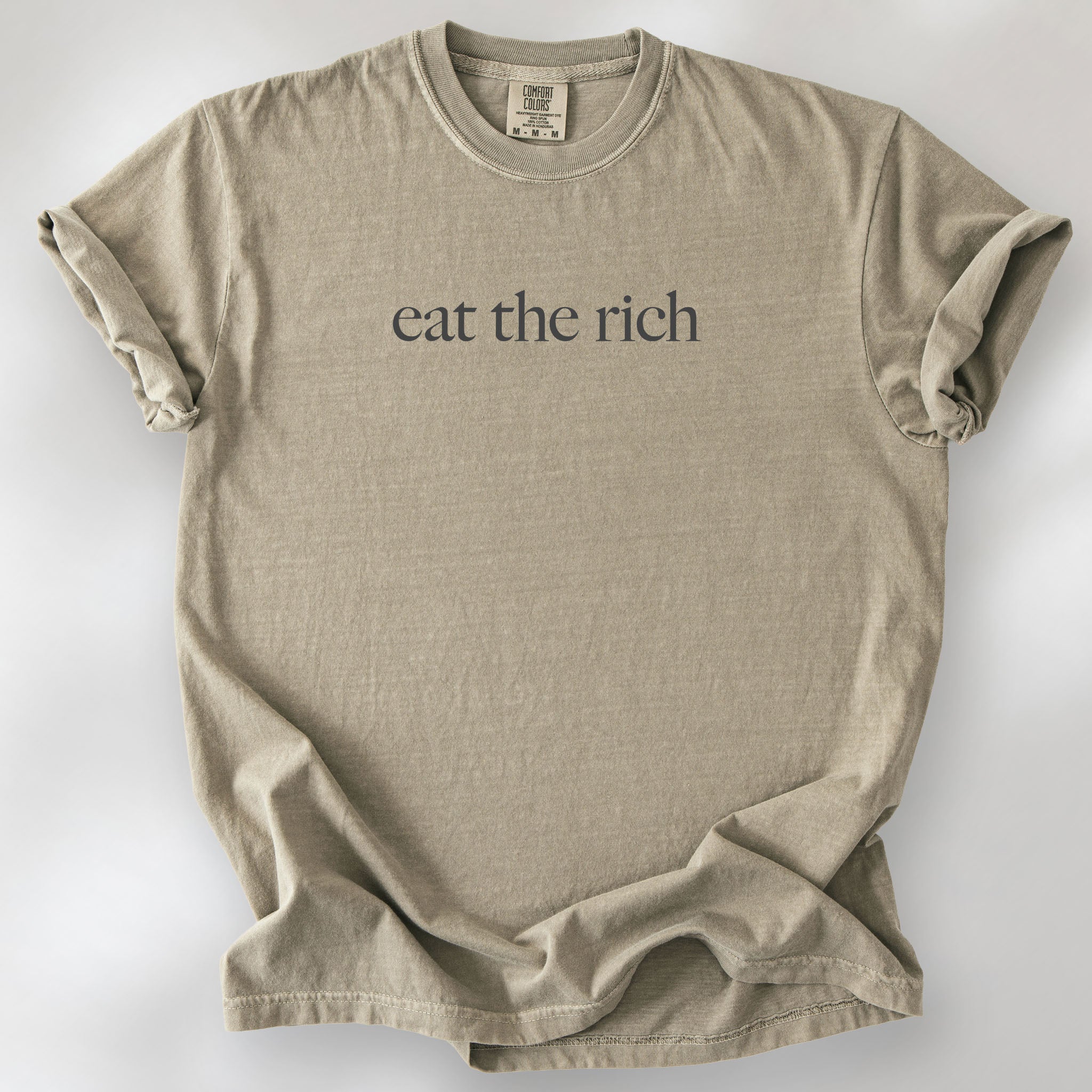 Khaki t-shirt with minimalist dark grey text reading “eat the rich."
