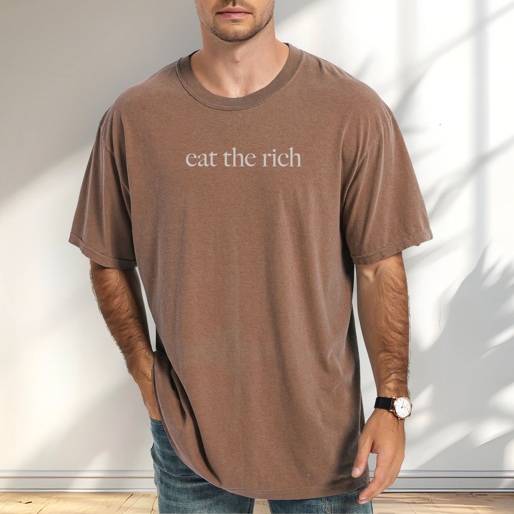 Male model wearing espresso t-shirt with minimalist light grey text reading “eat the rich."