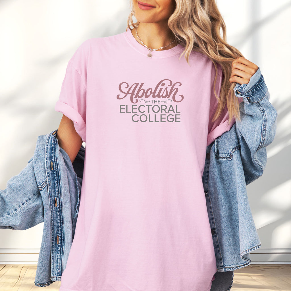 Female model wearing blossom t-shirt with stylized text reading “Abolish the Electoral College” in muted red and gray, minimalist pro-democracy design.