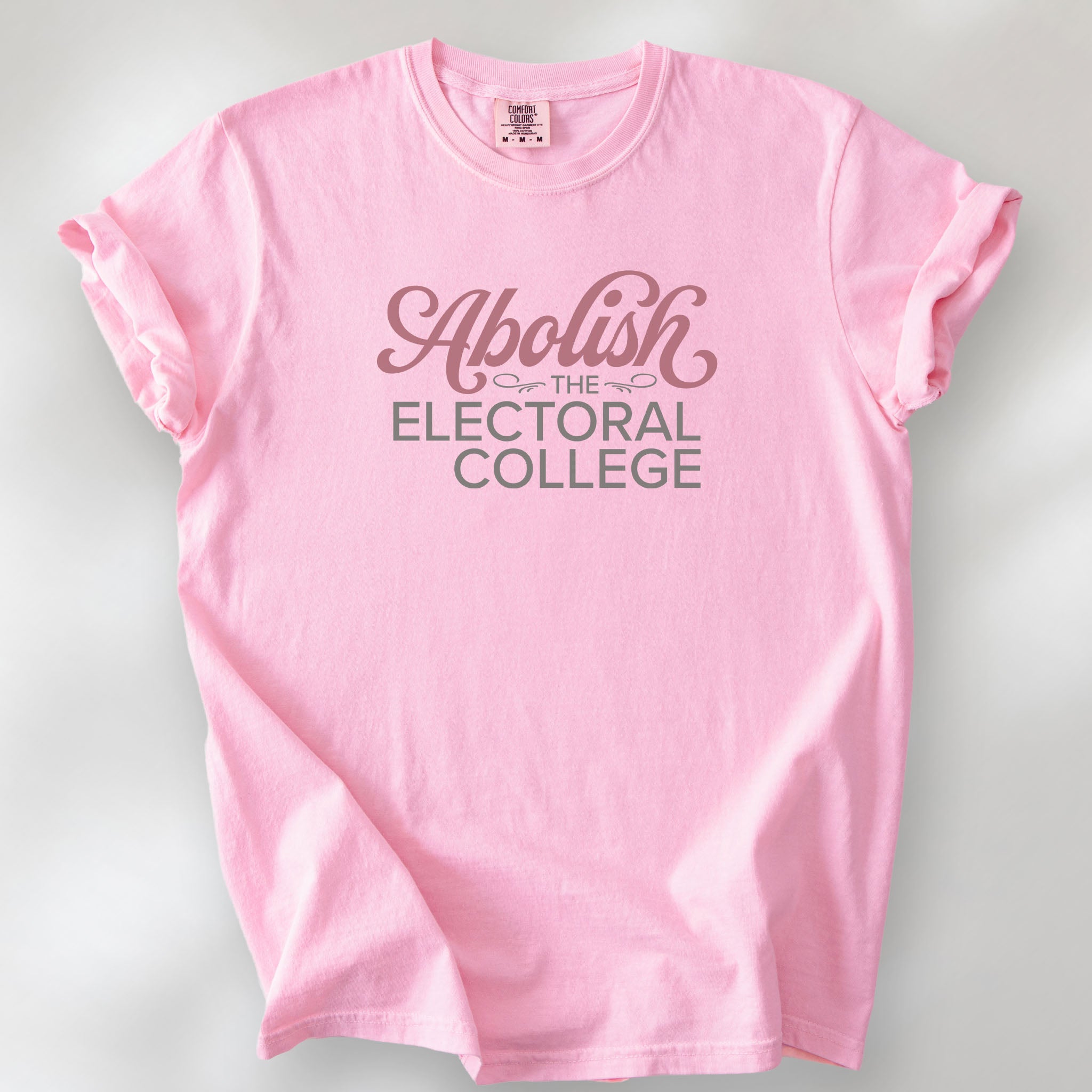 Blossom t-shirt with stylized text reading “Abolish the Electoral College” in muted red and gray, minimalist pro-democracy design.