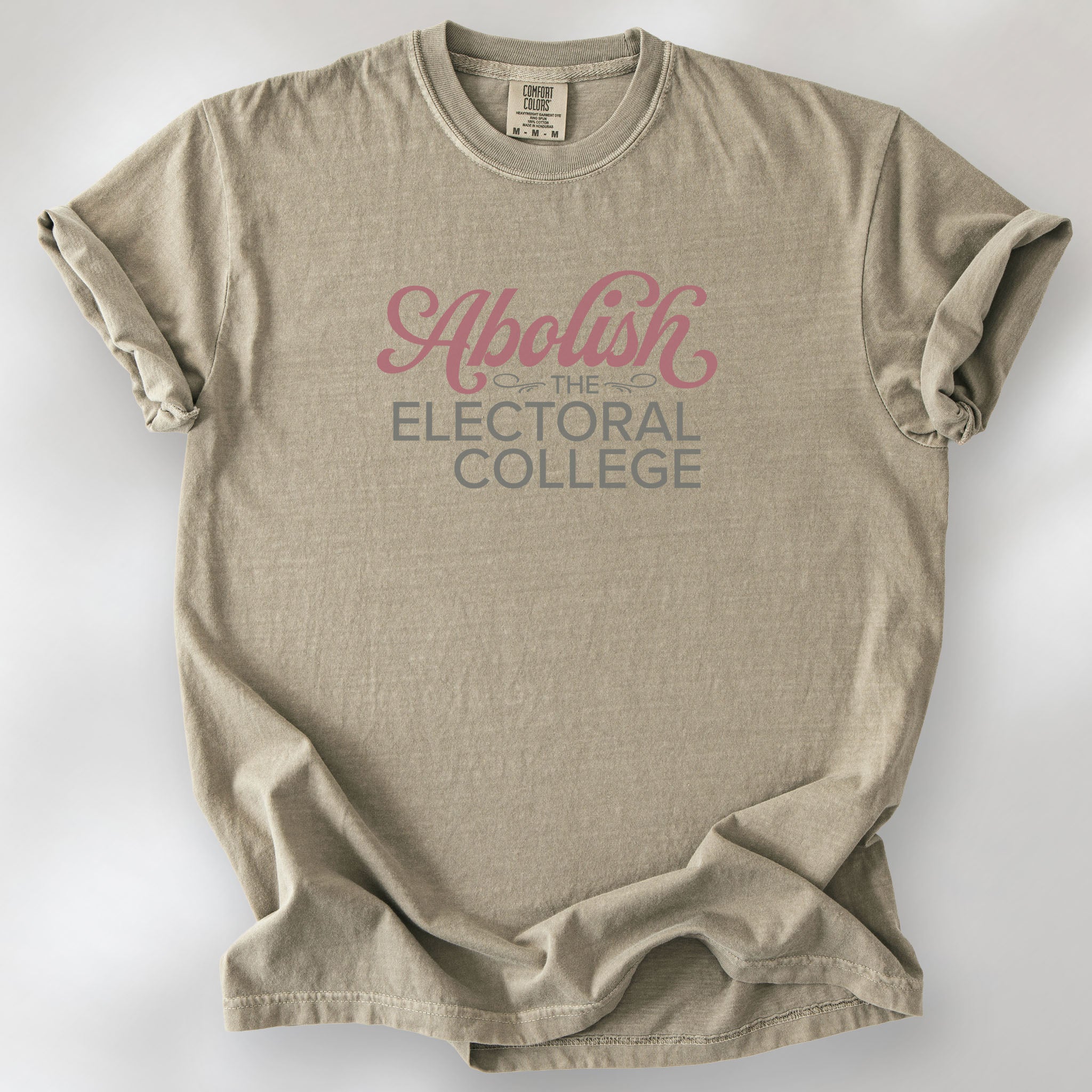 Khaki t-shirt with stylized text reading “Abolish the Electoral College” in muted red and gray, minimalist pro-democracy design.