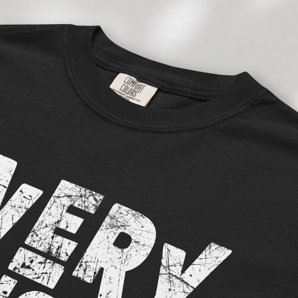 Closeup detail of black t-shirt featuring distressed block typography reading "Everything Is Political" in a bold minimalist design.