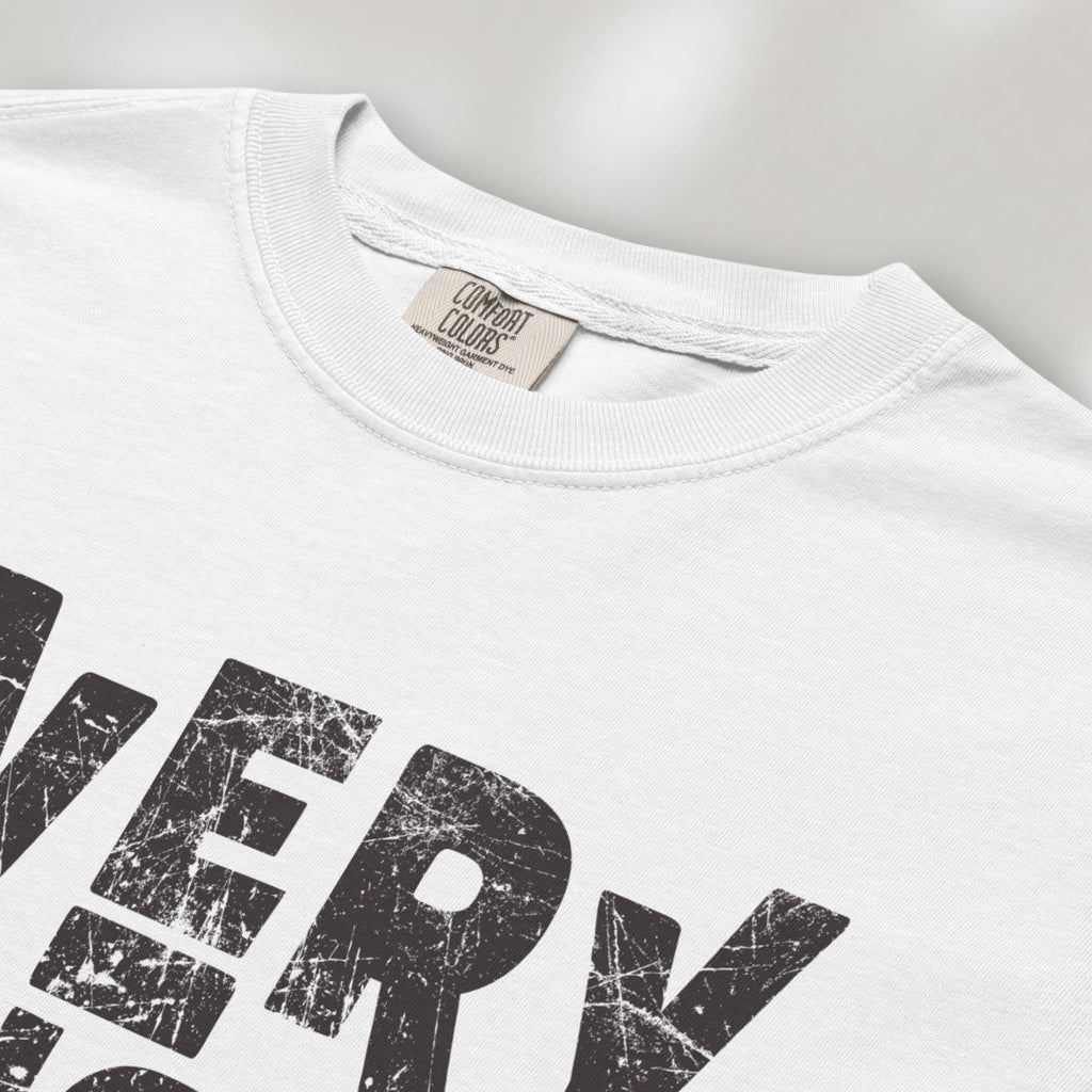 Closeup detail of white t-shirt featuring distressed block typography reading "Everything Is Political" in a bold minimalist design.