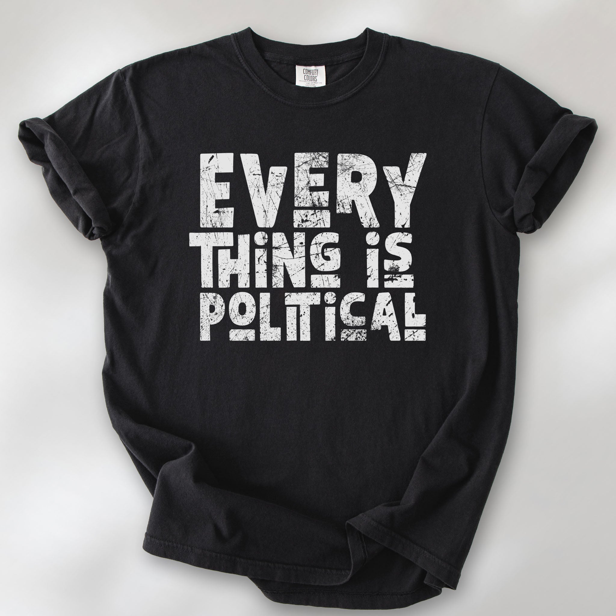 Black t-shirt featuring distressed block typography reading "Everything Is Political" in a bold minimalist design.
