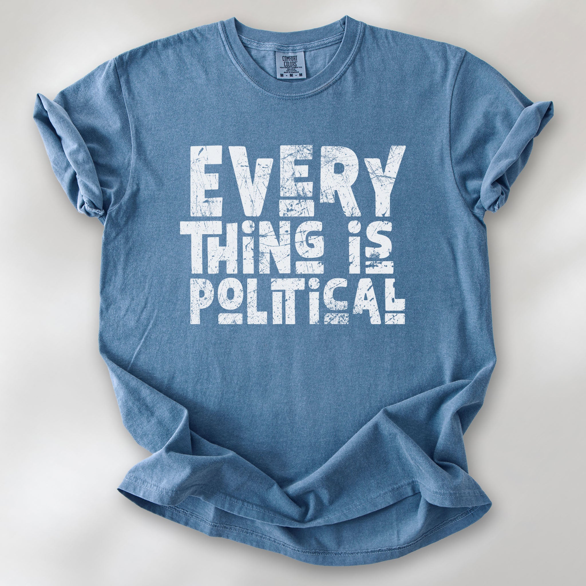 Blue jean t-shirt featuring distressed block typography reading "Everything Is Political" in a bold minimalist design.