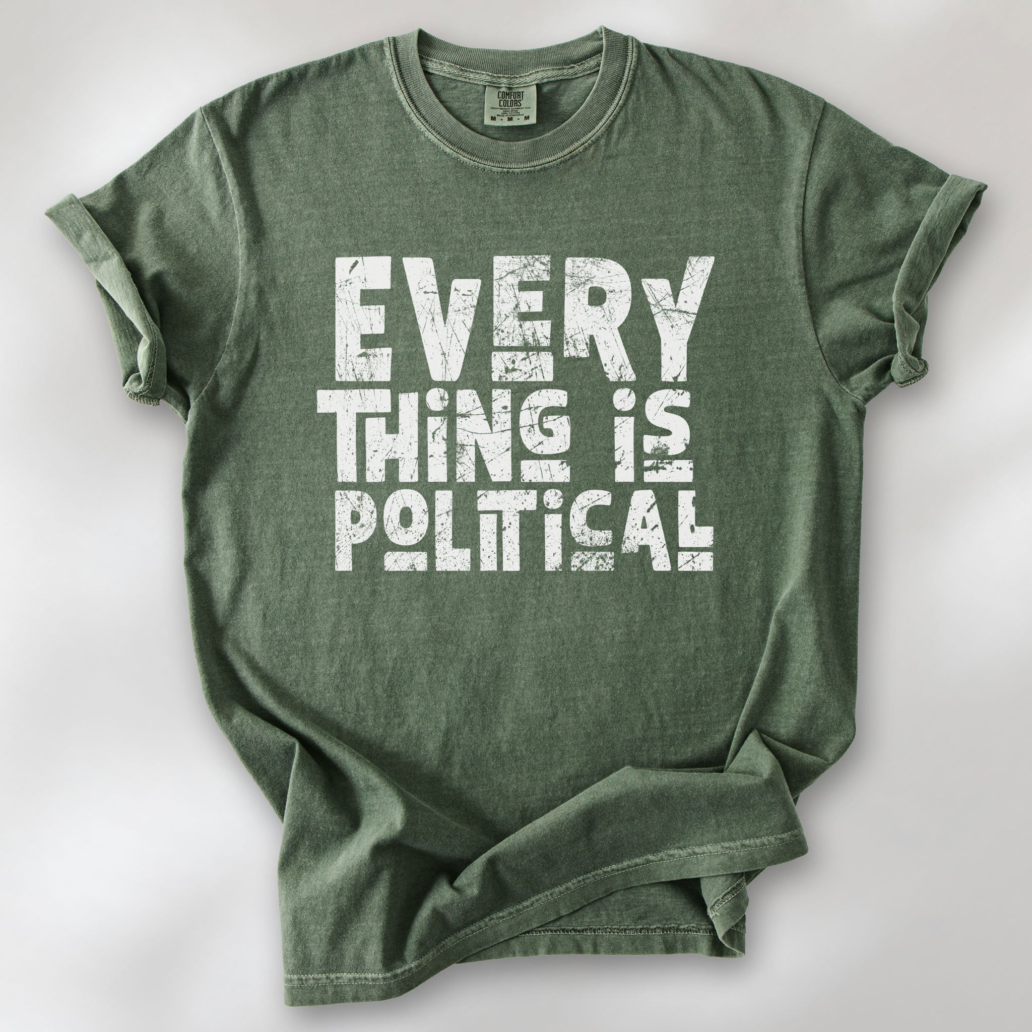 Moss t-shirt featuring distressed block typography reading "Everything Is Political" in a bold minimalist design.