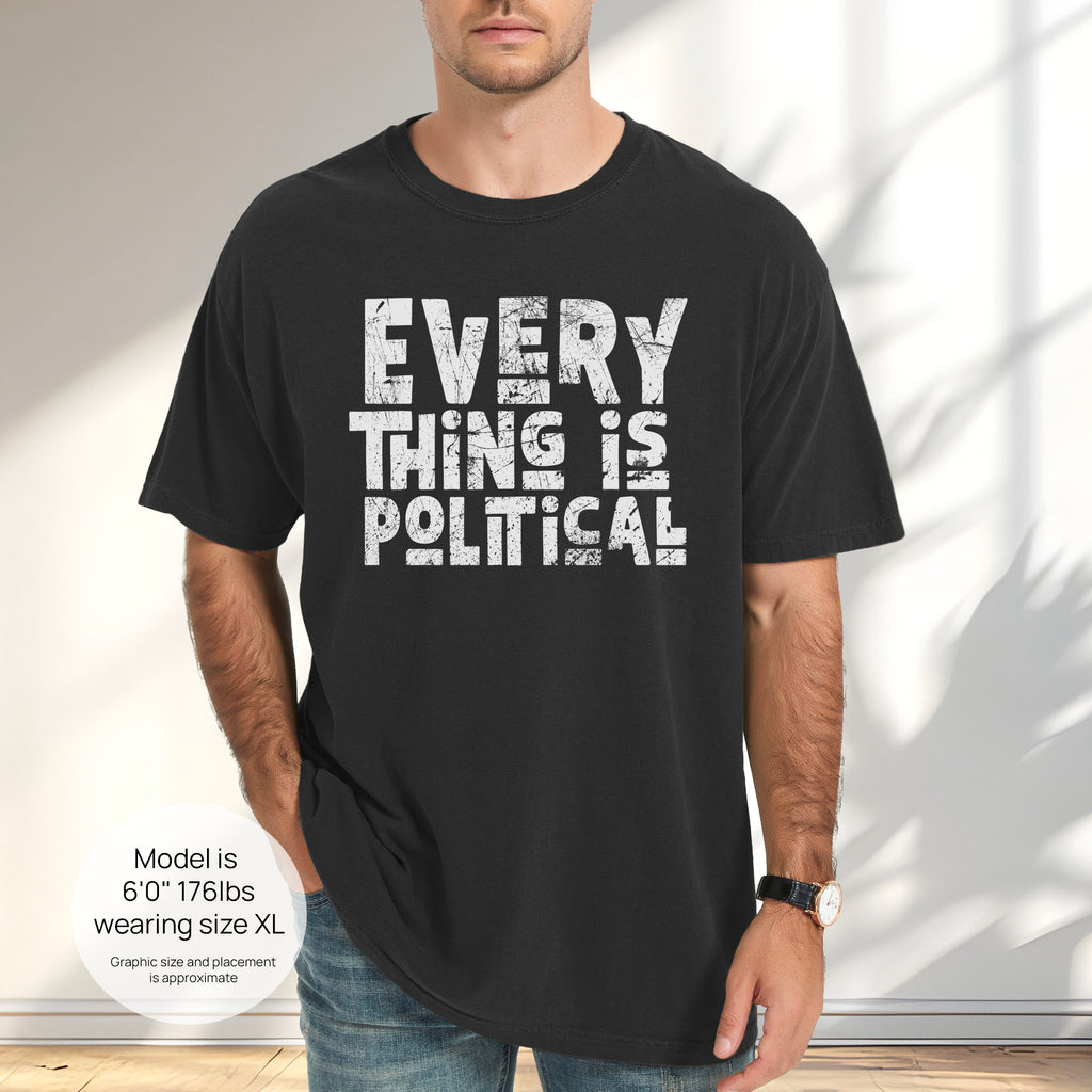 Male model wearing black t-shirt featuring distressed block typography reading "Everything Is Political" in a bold minimalist design. Includes size and fit information for the model who is 6 feet 0 inches, 176 pounds, and wearing a size XL shirt.
