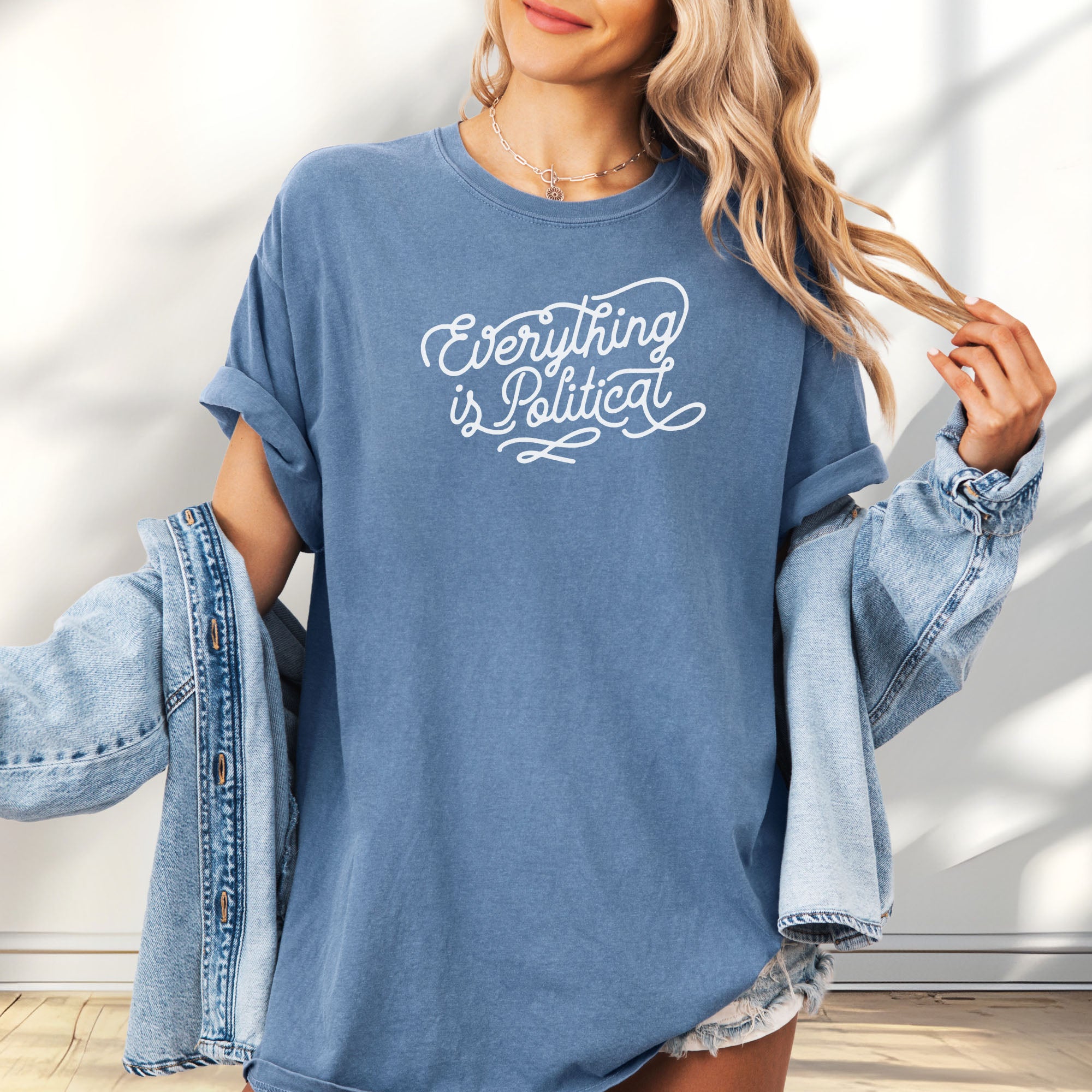 Female model wearing oversized blue jean minimalist script everything is political activist shirt.