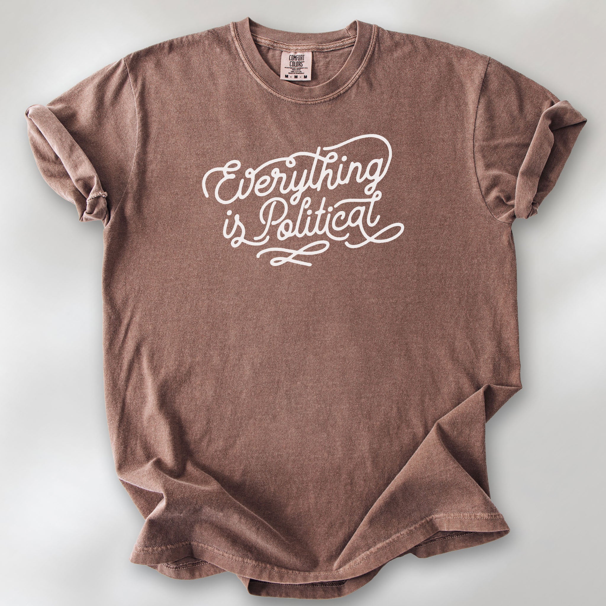 Espresso shirt with minimalist script "everything is political" graphic.