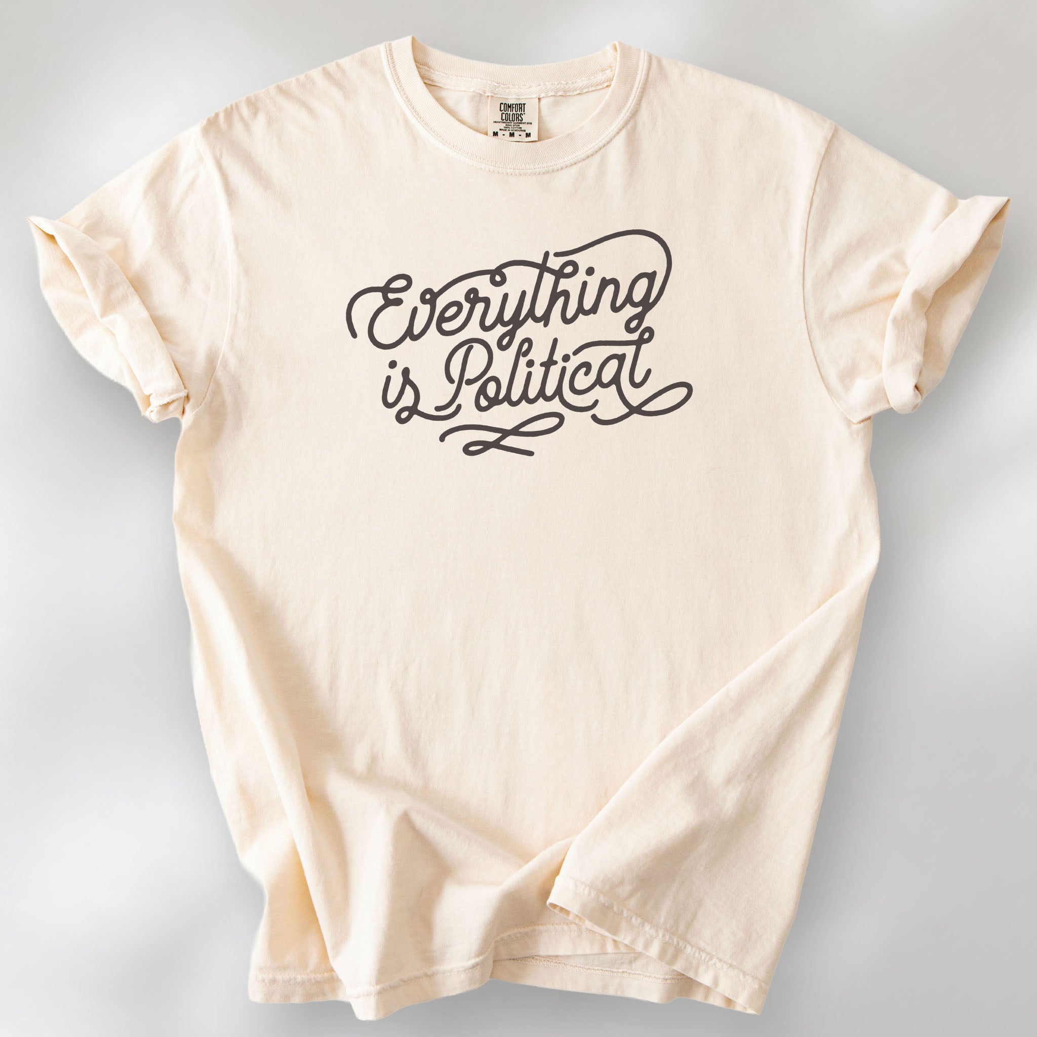 Ivory shirt with minimalist script "everything is political" graphic.