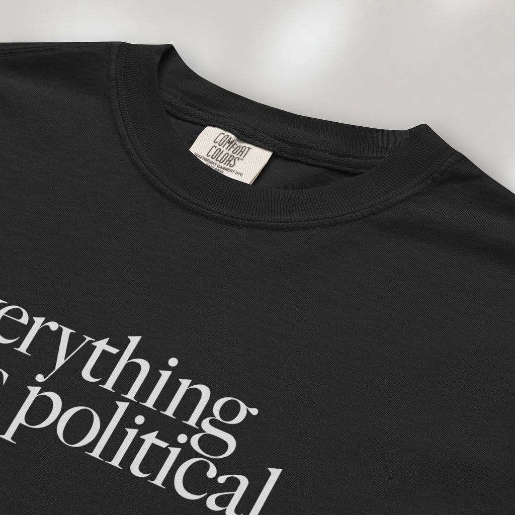 Closeup detail of black unisex t-shirt with minimalist serif gray text reading “everything is political."