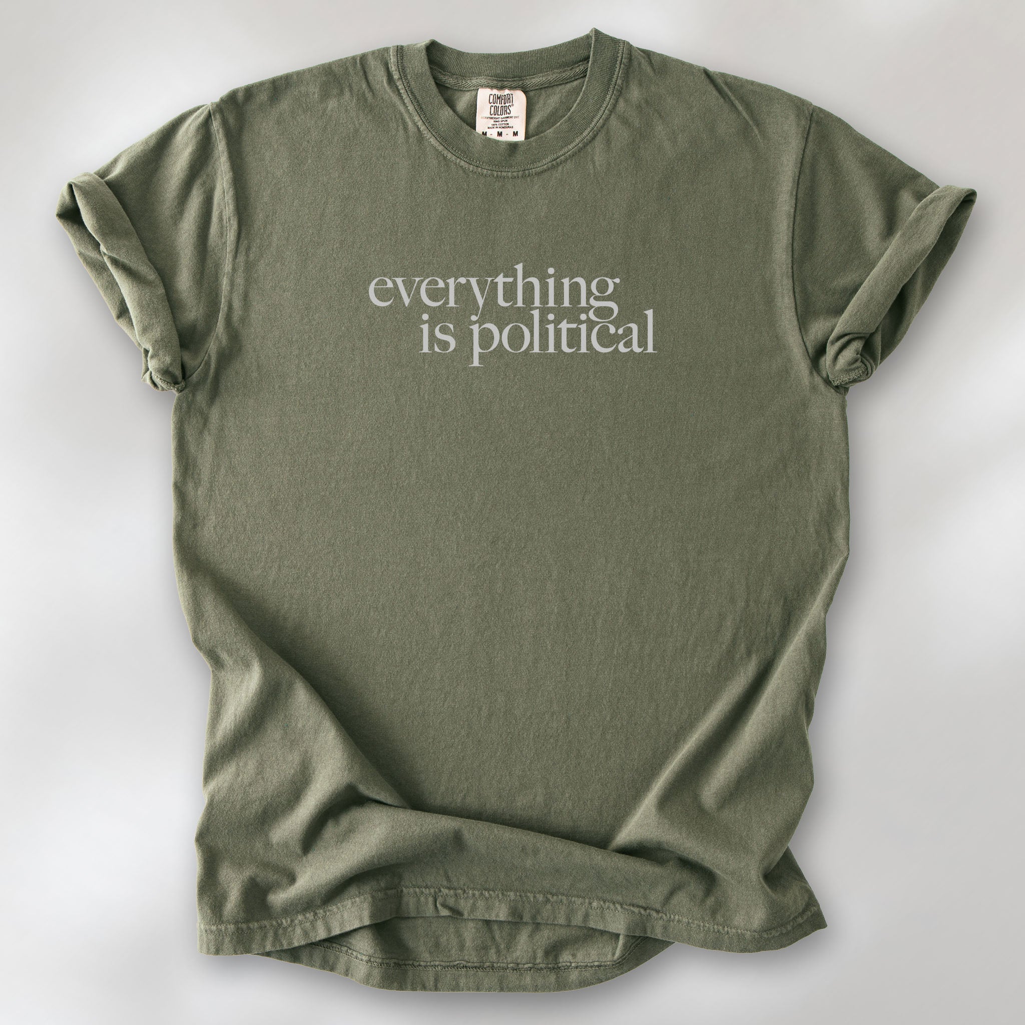 Sage unisex t-shirt with minimalist serif gray text reading “everything is political."