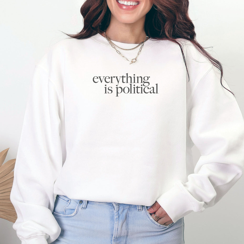 Female model wearing white sweatshirt with minimalist serif gray text reading “everything is political."
