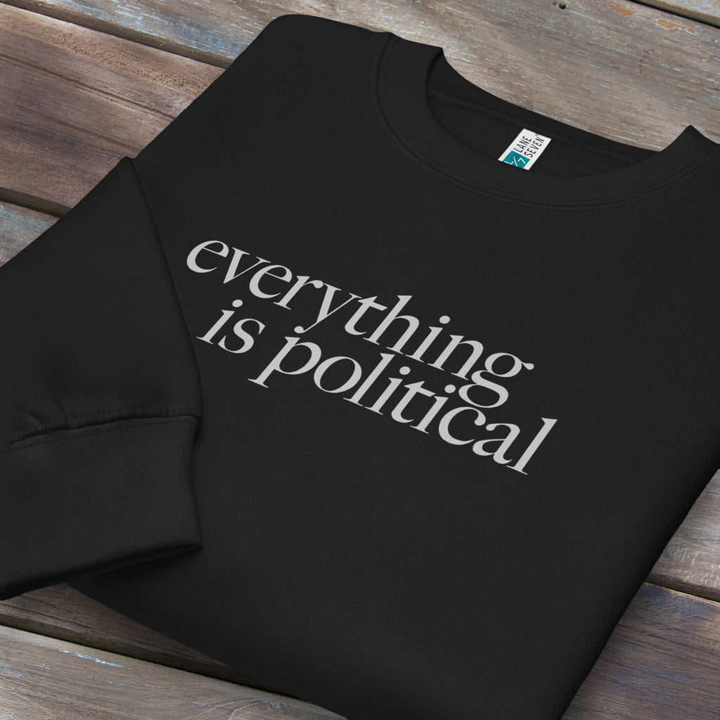 Folded black sweatshirt with minimalist serif gray text reading “everything is political."