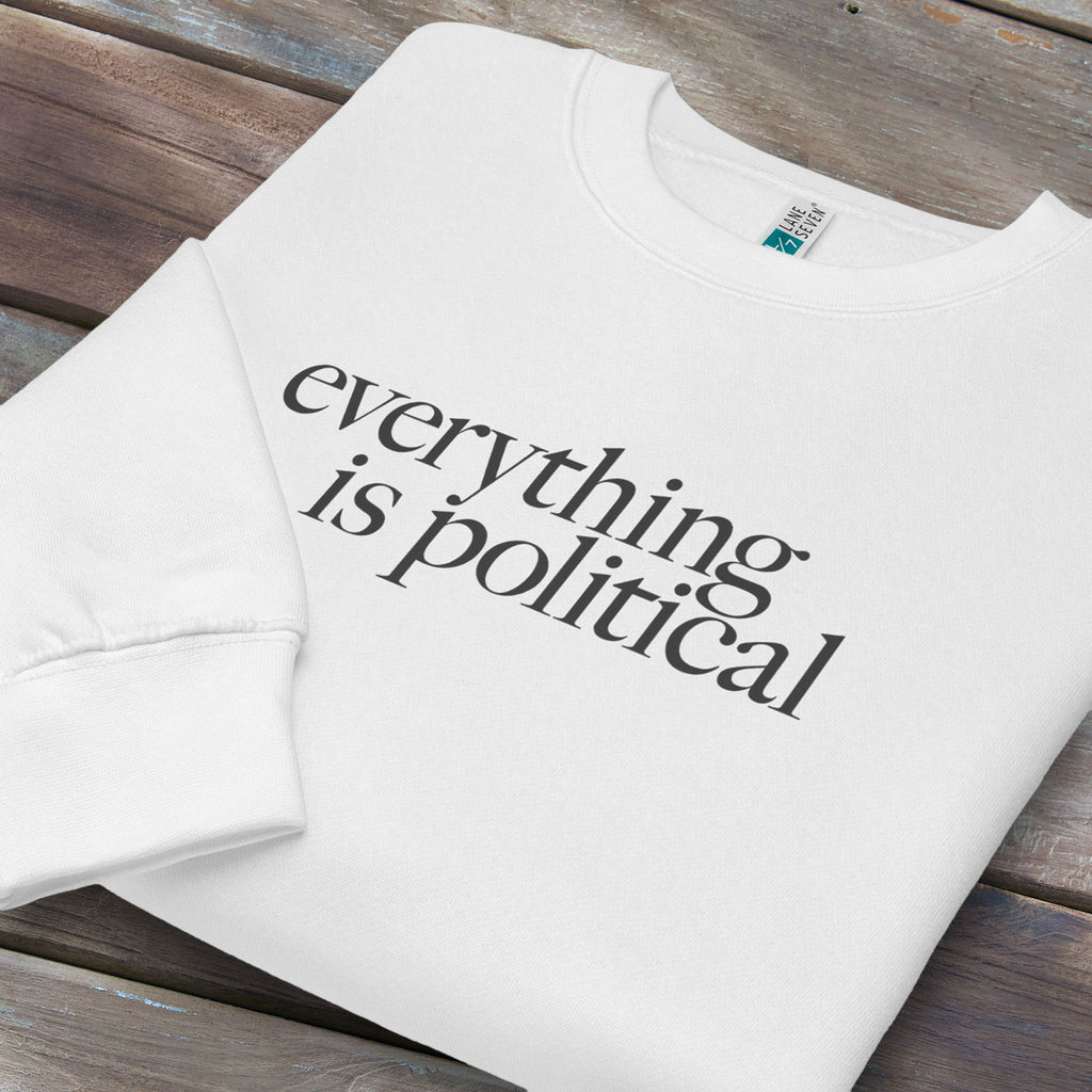 Folded white sweatshirt with minimalist serif gray text reading “everything is political."