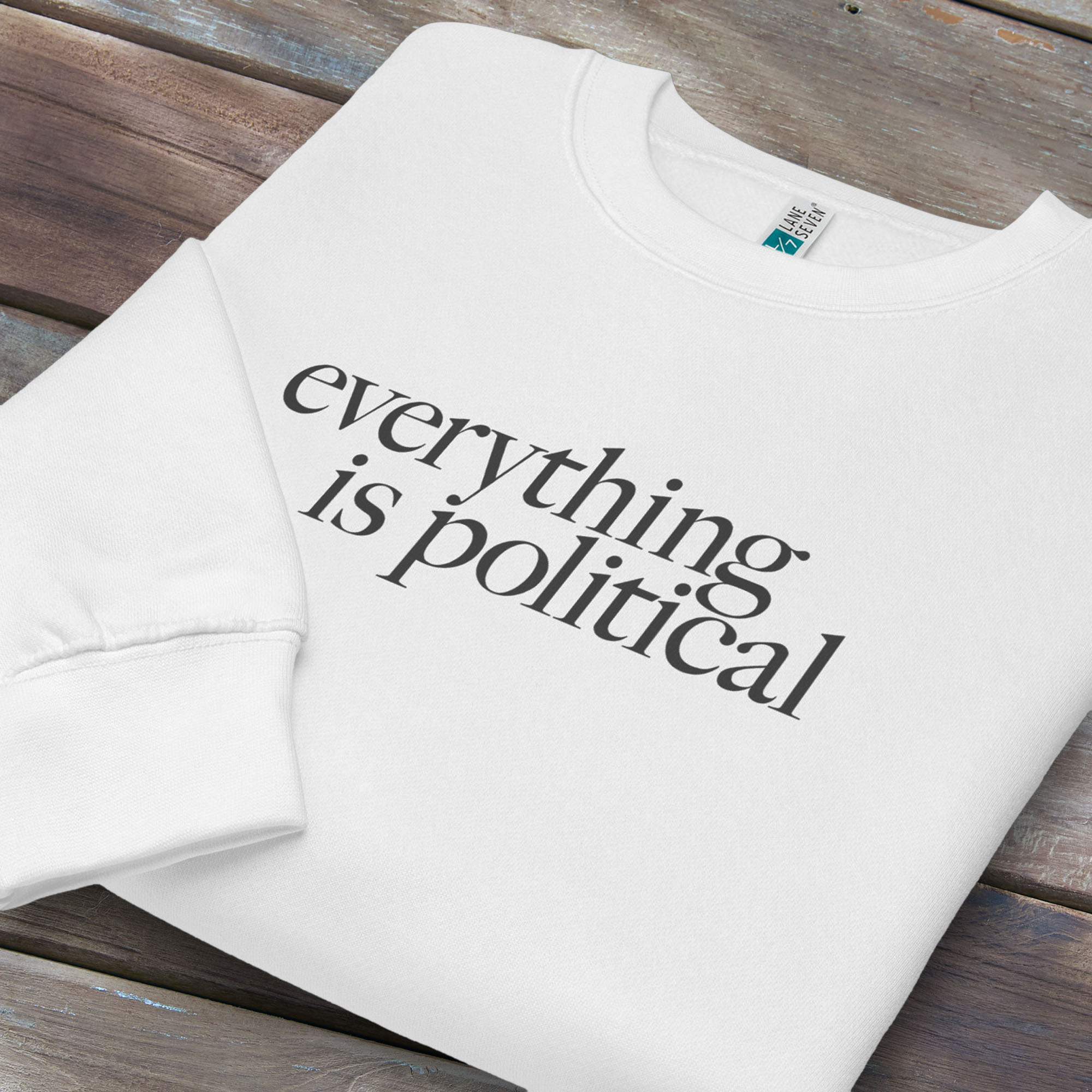 Folded white sweatshirt with minimalist serif gray text reading “everything is political."
