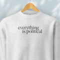 Hanging grey sweatshirt with minimalist serif gray text reading “everything is political."