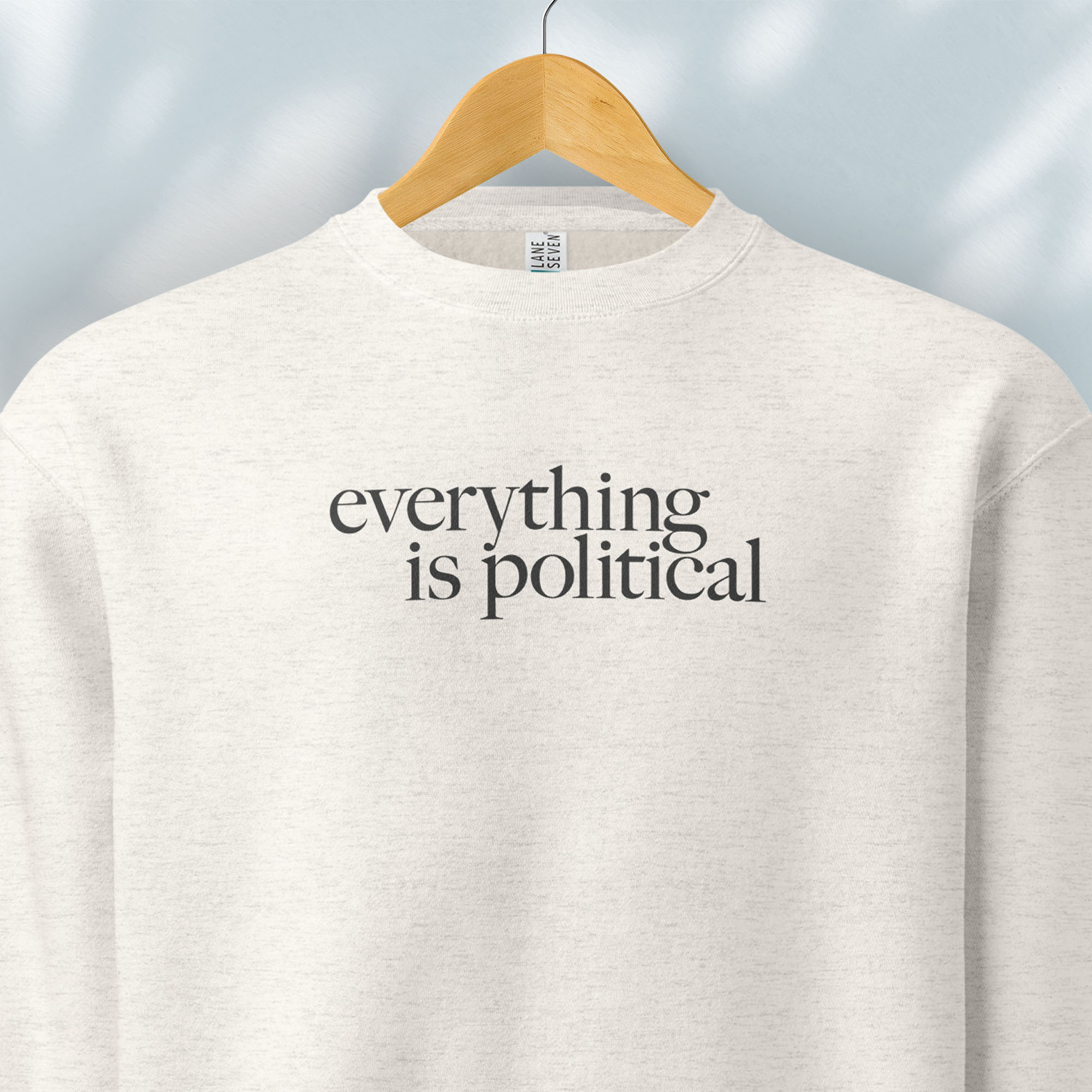 Hanging oatmeal sweatshirt with minimalist serif gray text reading “everything is political."