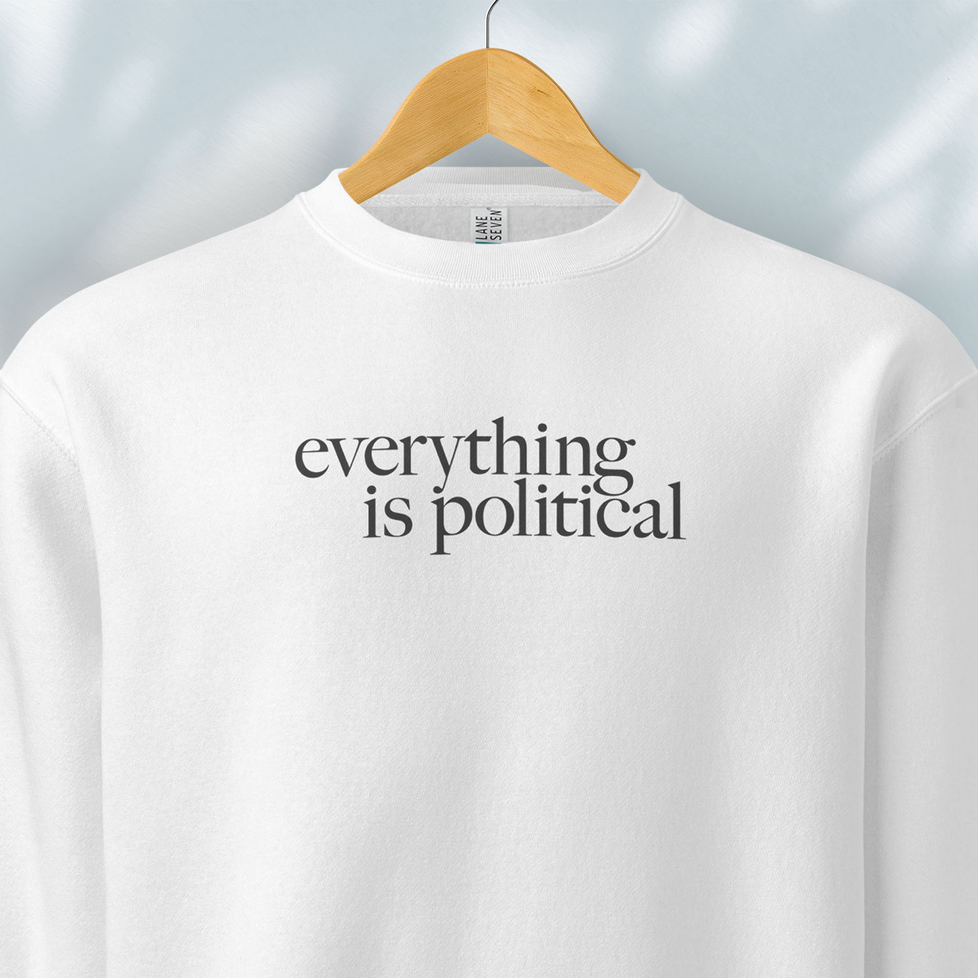 Hanging white sweatshirt with minimalist serif gray text reading “everything is political."