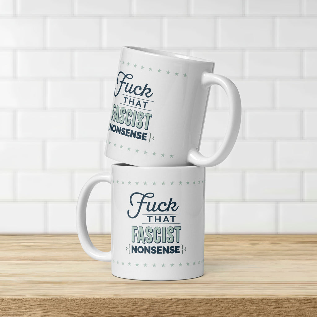 Two mugs stacked atop each other on a kitchen counter. Mugs reads "fuck that fascist nonsense" in stylized text block.