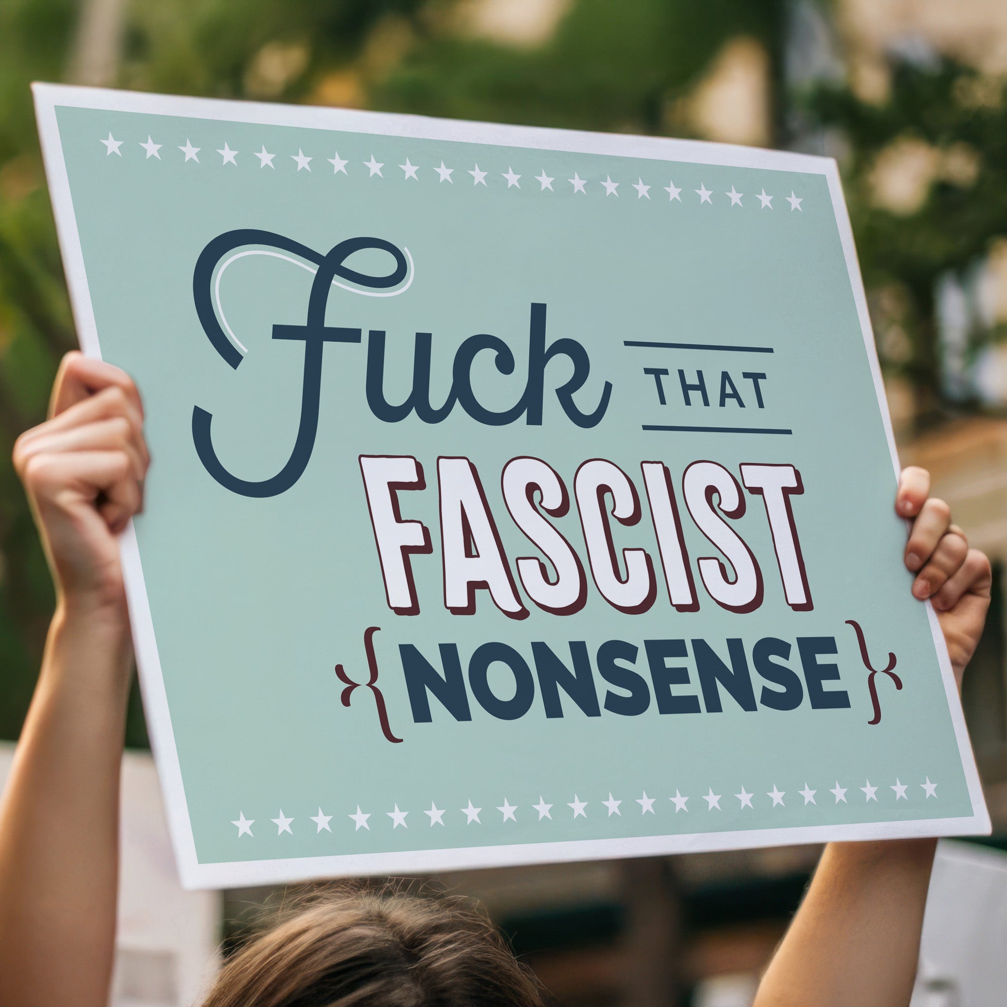 Anti-trump protest sign with stylized text design that reads "Fuck that fascist nonsense", held high in a crowd.
