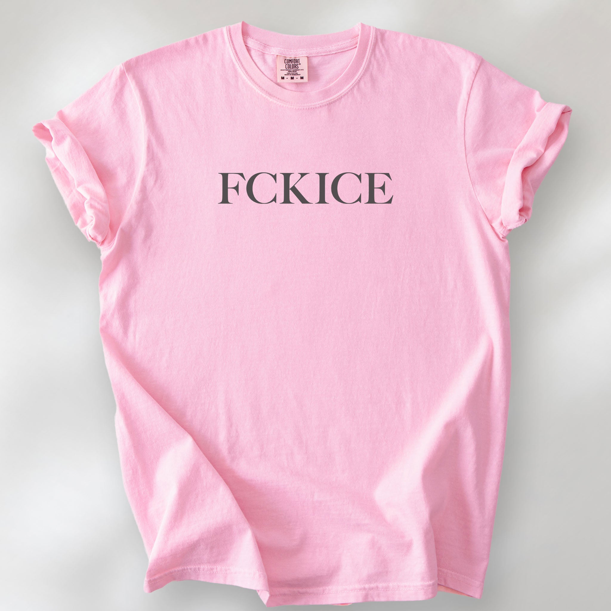 Blossom unisex t-shirt with minimalist serif typography reading “FCK ICE,” an anti-ICE political message opposing Immigration and Customs Enforcement abuses and violence.