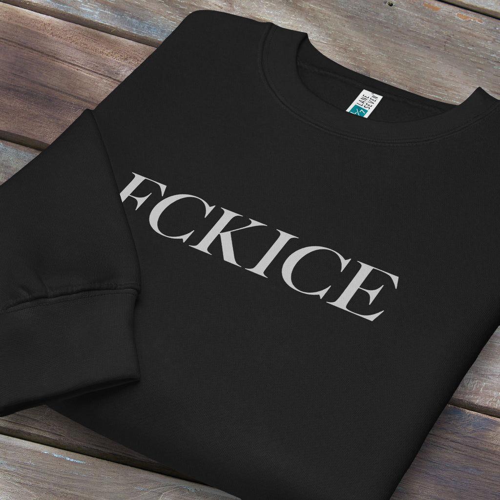 Folded black sweatshirt with minimalist serif typography reading “FCK ICE,” an anti-ICE political message opposing Immigration and Customs Enforcement abuses and violence.