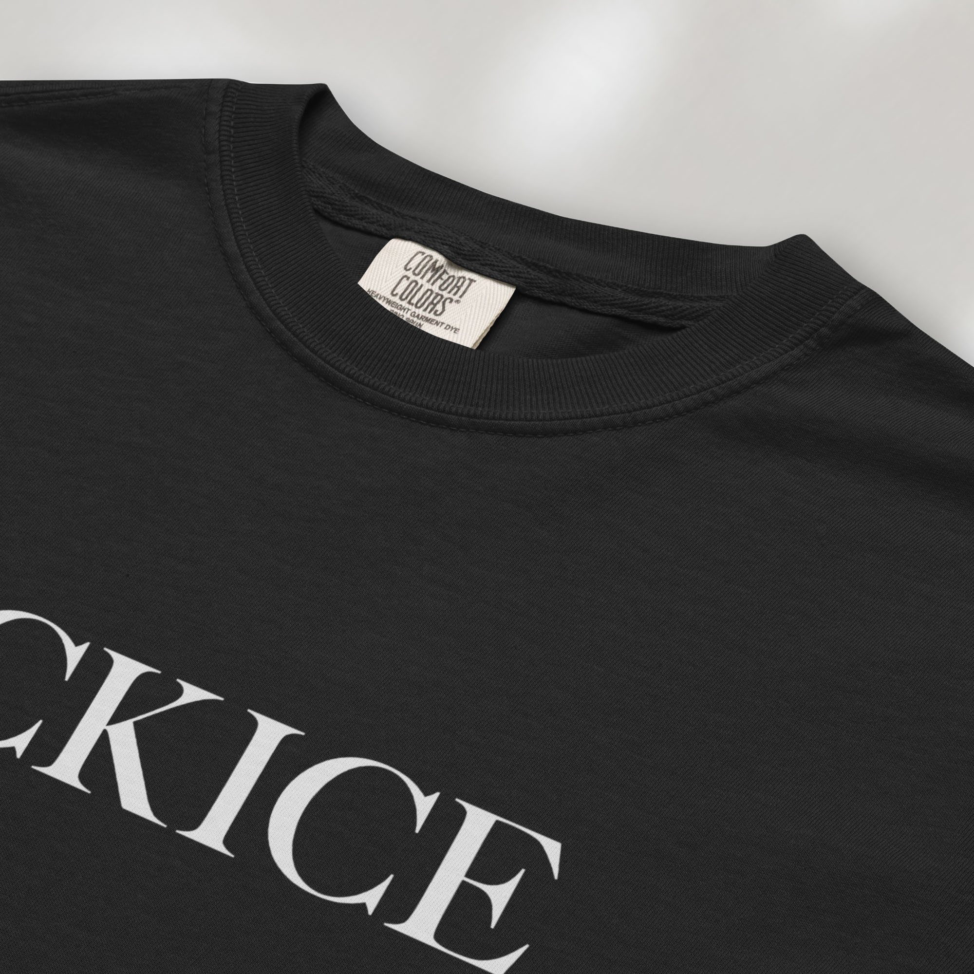 Closeup detail of black t-shirt with minimalist serif typography reading "FCK ICE."