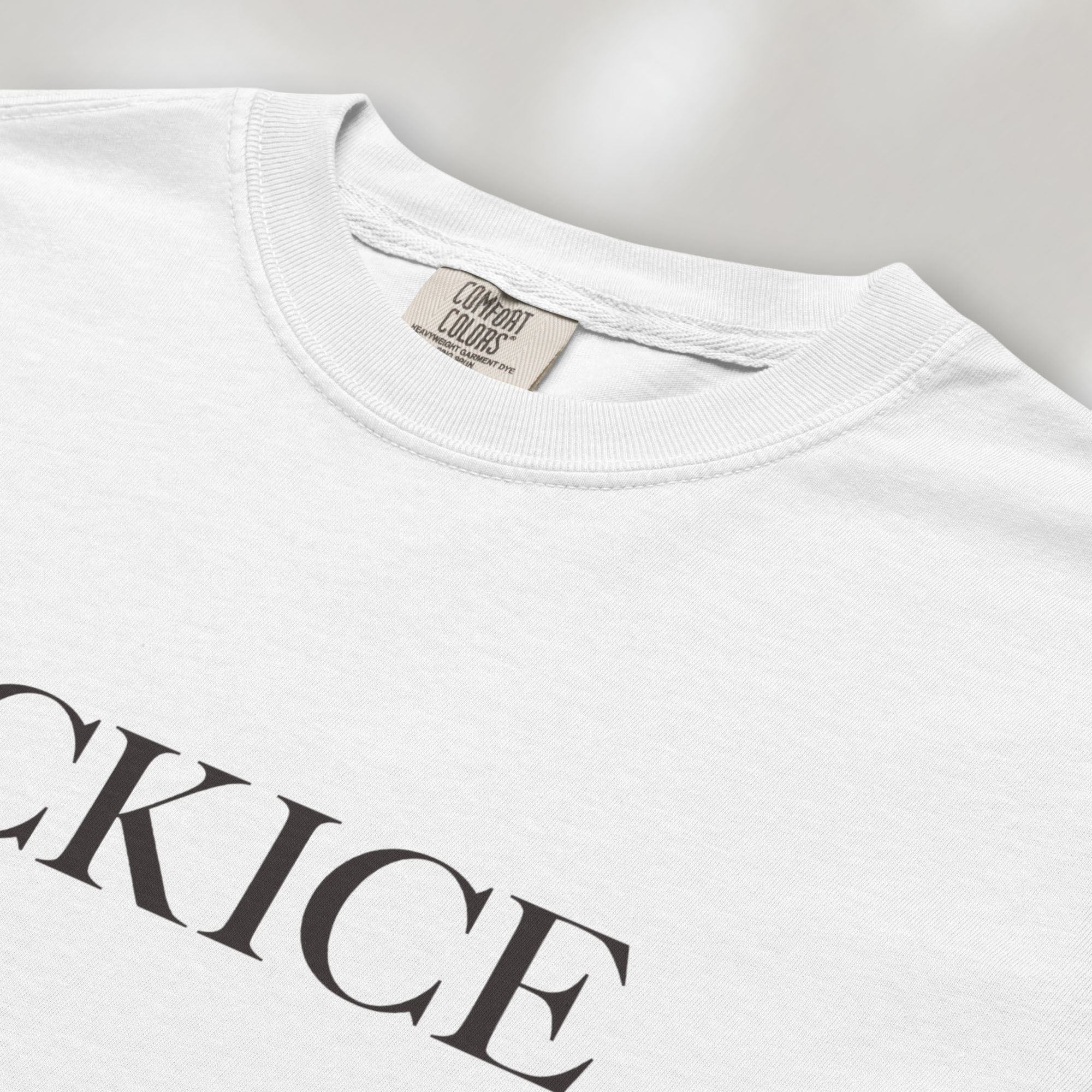 Closeup detail of white t-shirt with minimalist serif typography reading "FCK ICE."