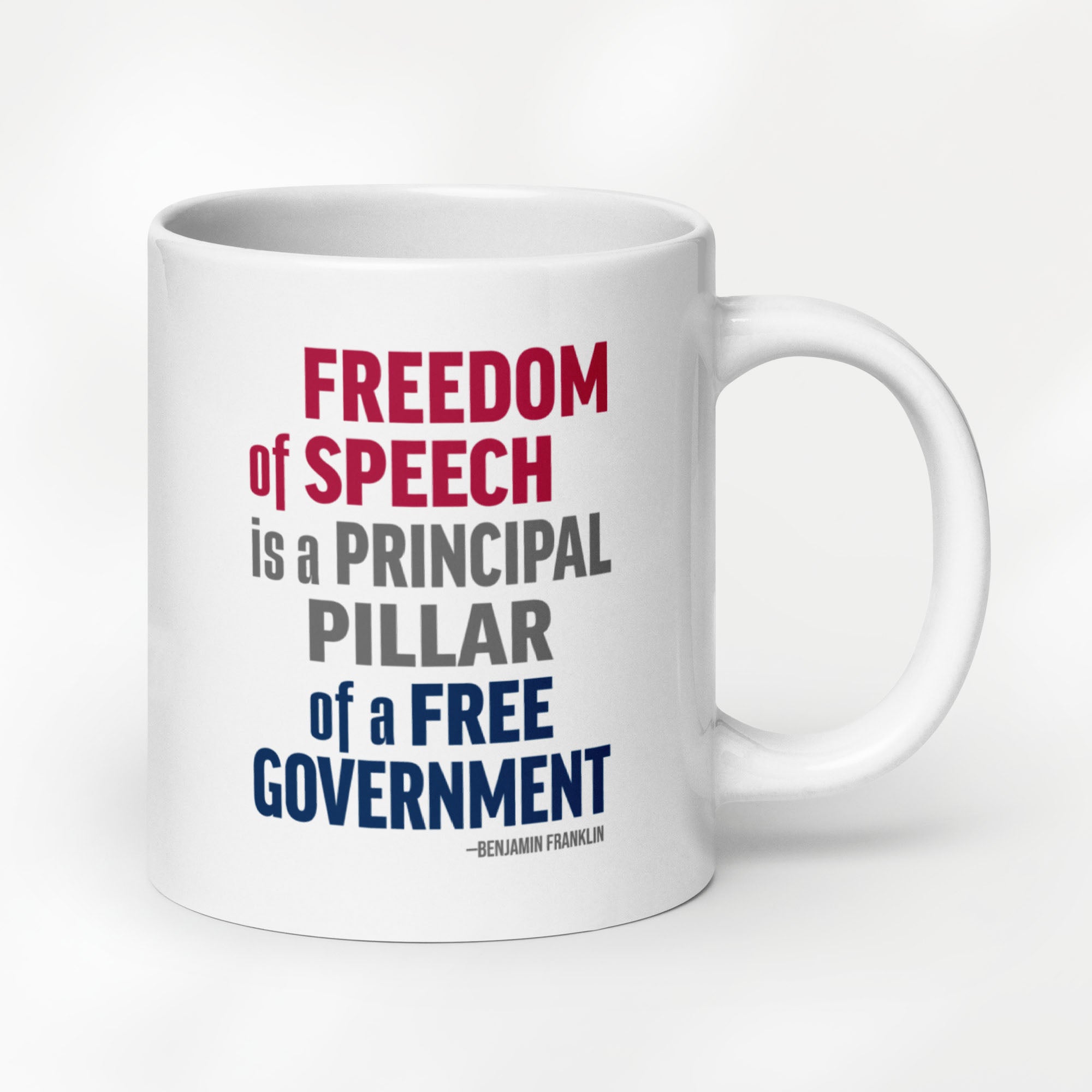 20 ounce white ceramic mug with bold patriotic red, blue, and grey text that reads "Freedom of speech is a principal pillar of a free government. – Ben Franklin." 