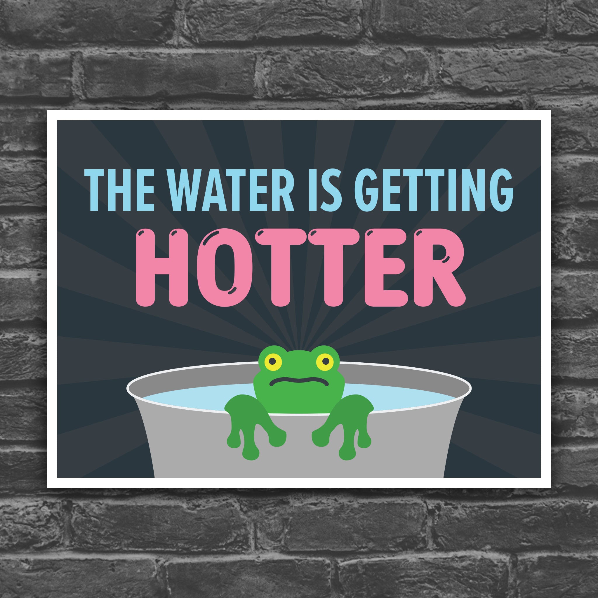 Color version of protest sign with bold text that says "The water is getting hotter" above a cartoon illustration of a panicked frog in a pot of water.