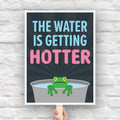 Downloadable, printable anti-trump protest sign with bold text in blue and pink that says "The water is getting hotter" above a cartoon illustration of a panicked frog in a pot of water.