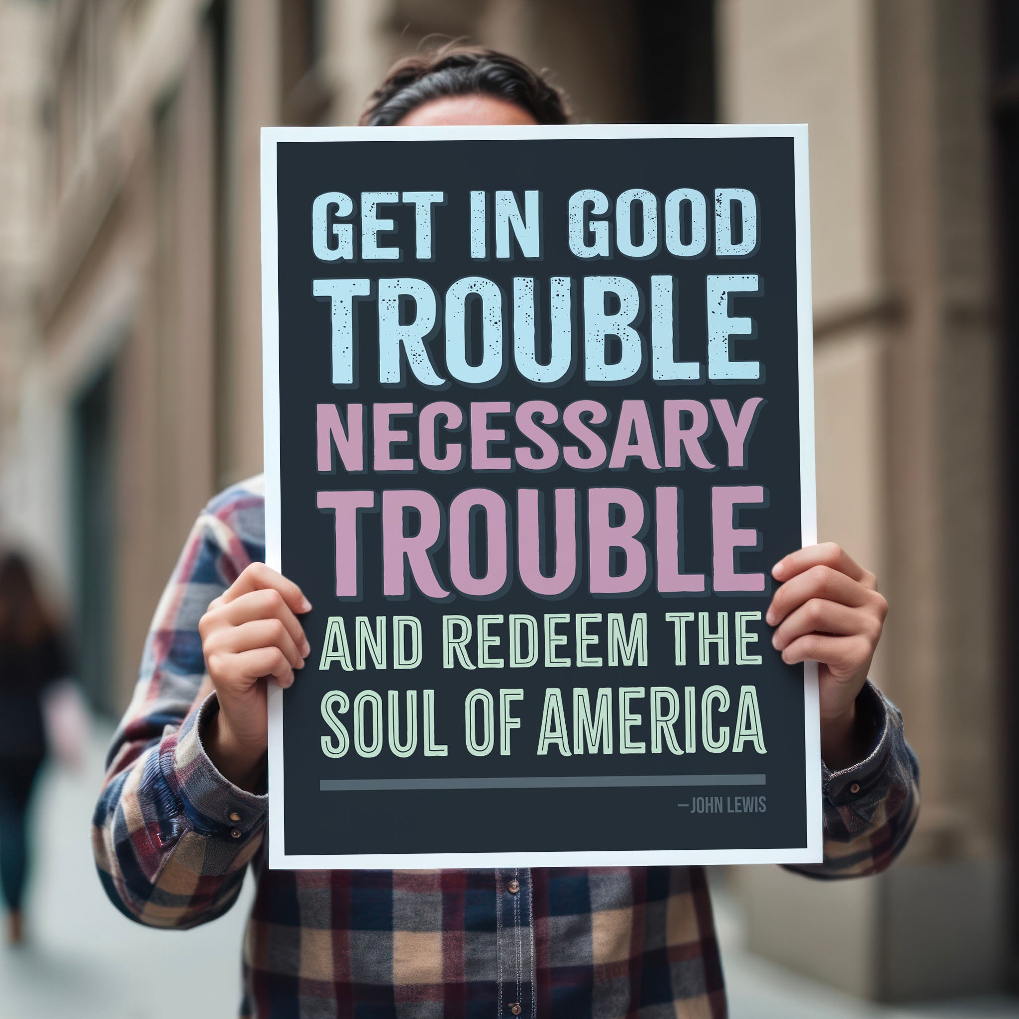Person holding protest sign with a dark background featuring the quote "Get in Good Trouble, Necessary Trouble, and Redeem the Soul of America" in large, bold, colorful text. The quote is attributed to John Lewis.