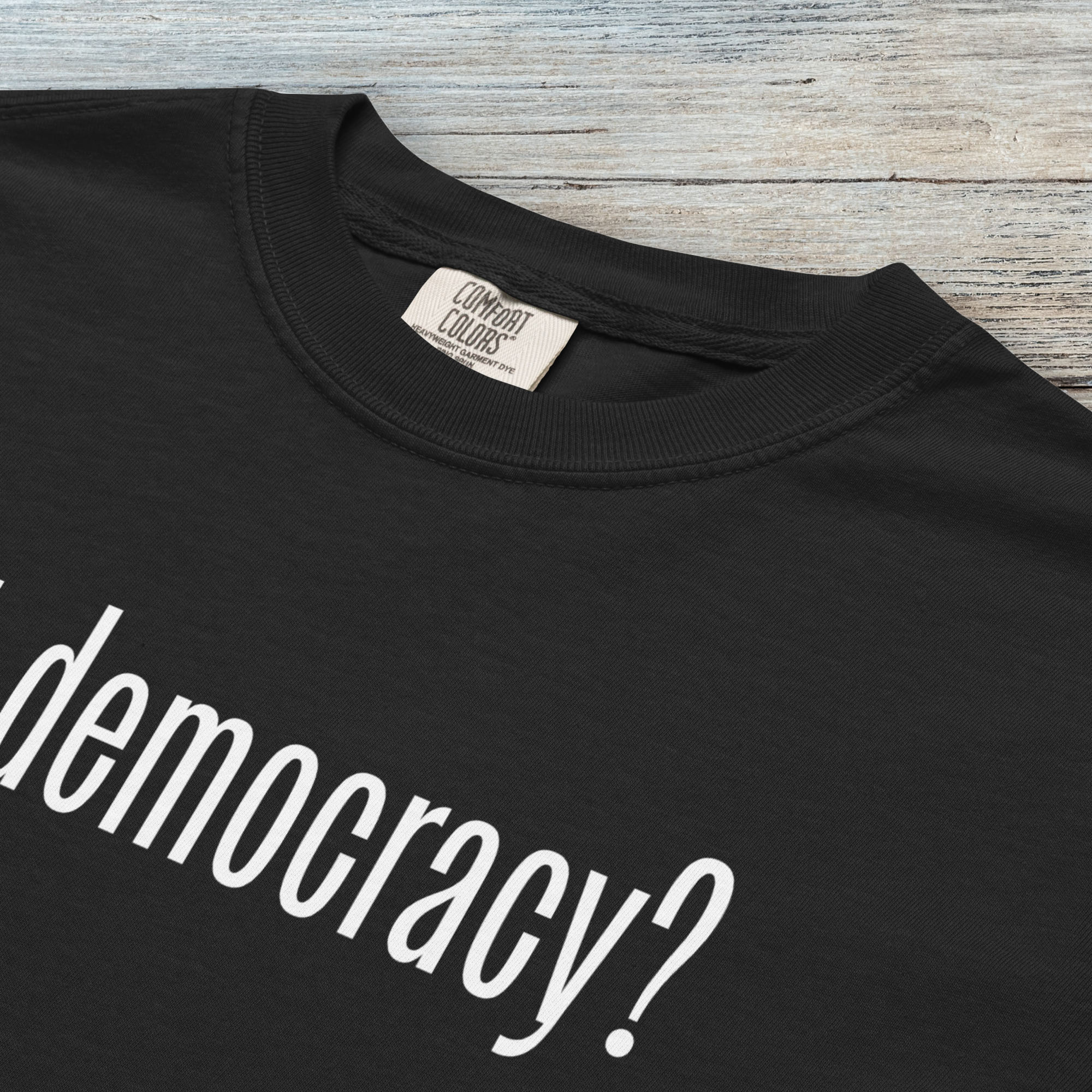 Closeup detail of black t-shirt with white text reading “got democracy?” in minimalist font, styled like the classic “got milk?” design.