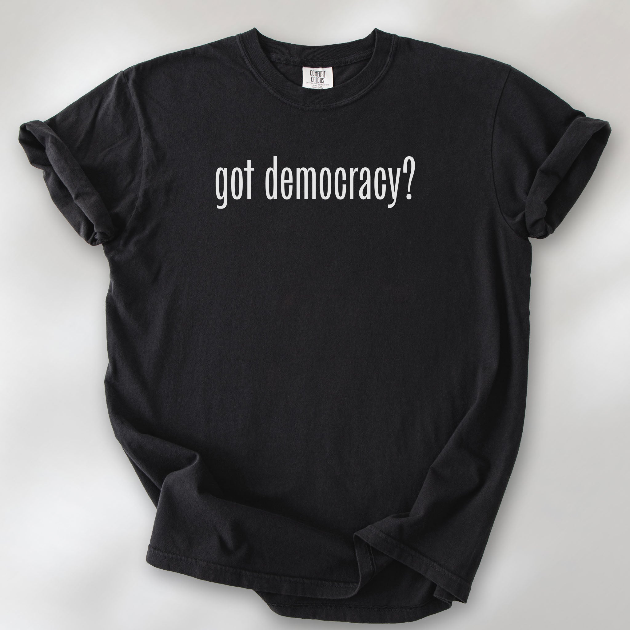 Black t-shirt with white text reading “got democracy?” in minimalist font, styled like the classic “got milk?” campaign design.