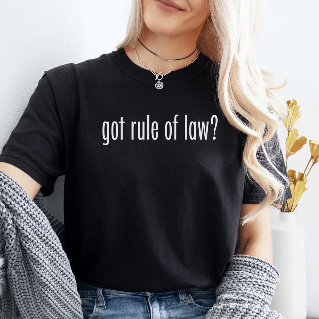 Female model wearing black t-shirt with white text reading “got rule of law?” in minimalist font, styled like the classic “got milk?” design.