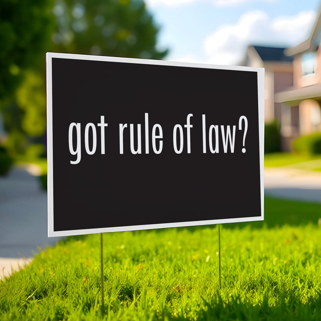Yard sign with black background and bold white text that says “got rule of law?” in the style of the “got milk?” campaign.