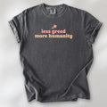 Pepper t-shirt featuring the phrase "Less Greed More Humanity" in soft retro typography with a small flower graphic above the text.