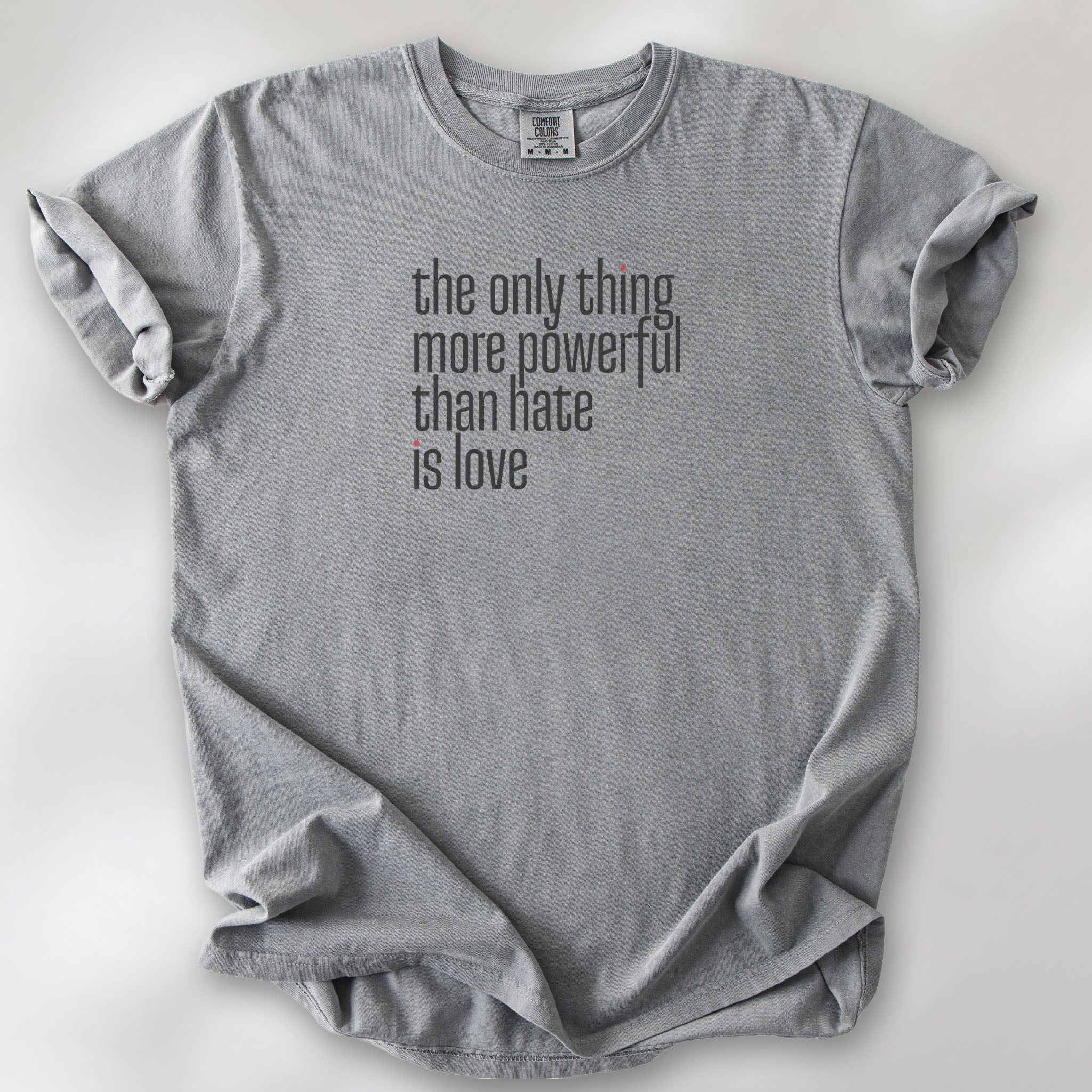 Grey t-shirt with a stylized text block reading “the only thing more powerful than hate is love."