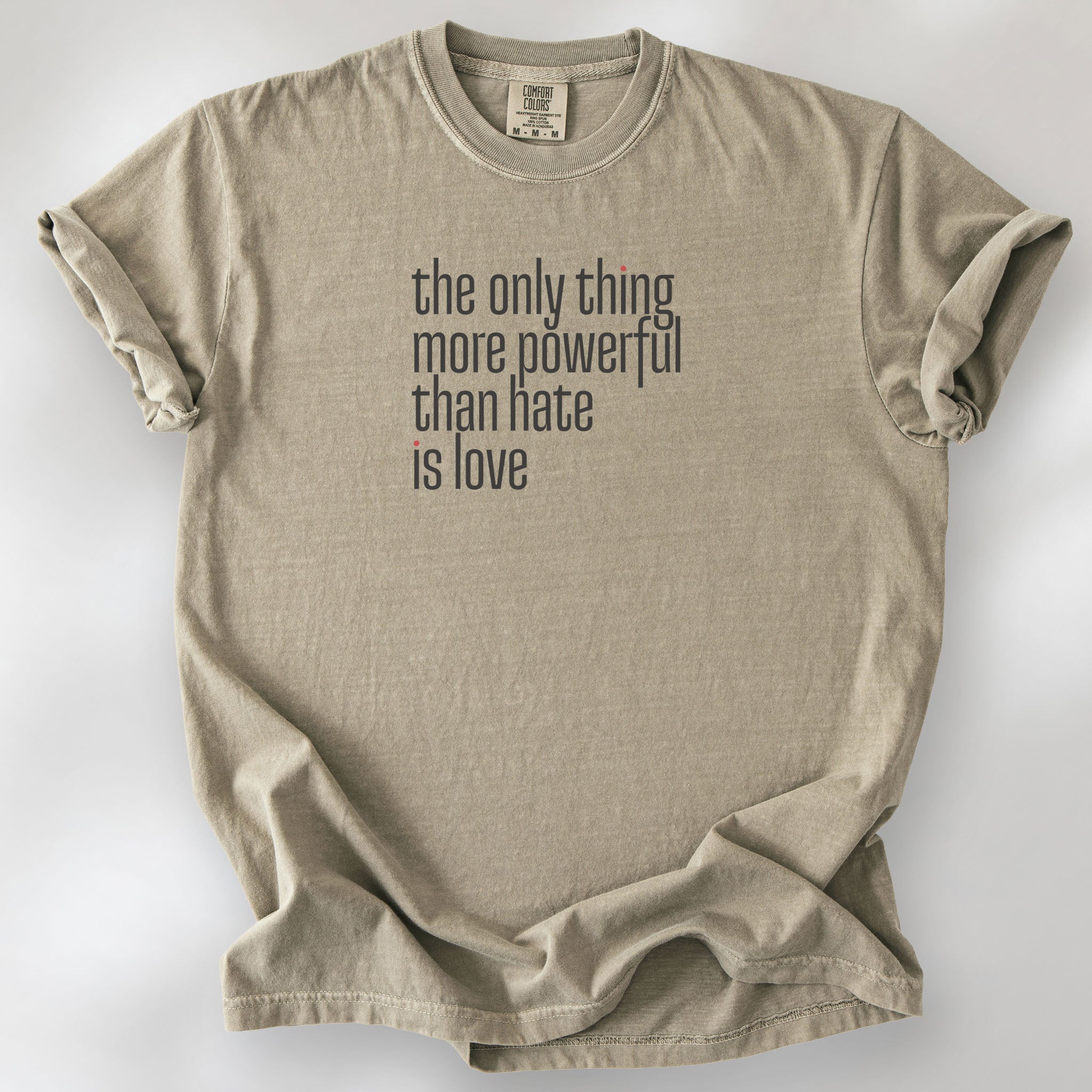 Khaki t-shirt with a stylized text block reading “the only thing more powerful than hate is love."