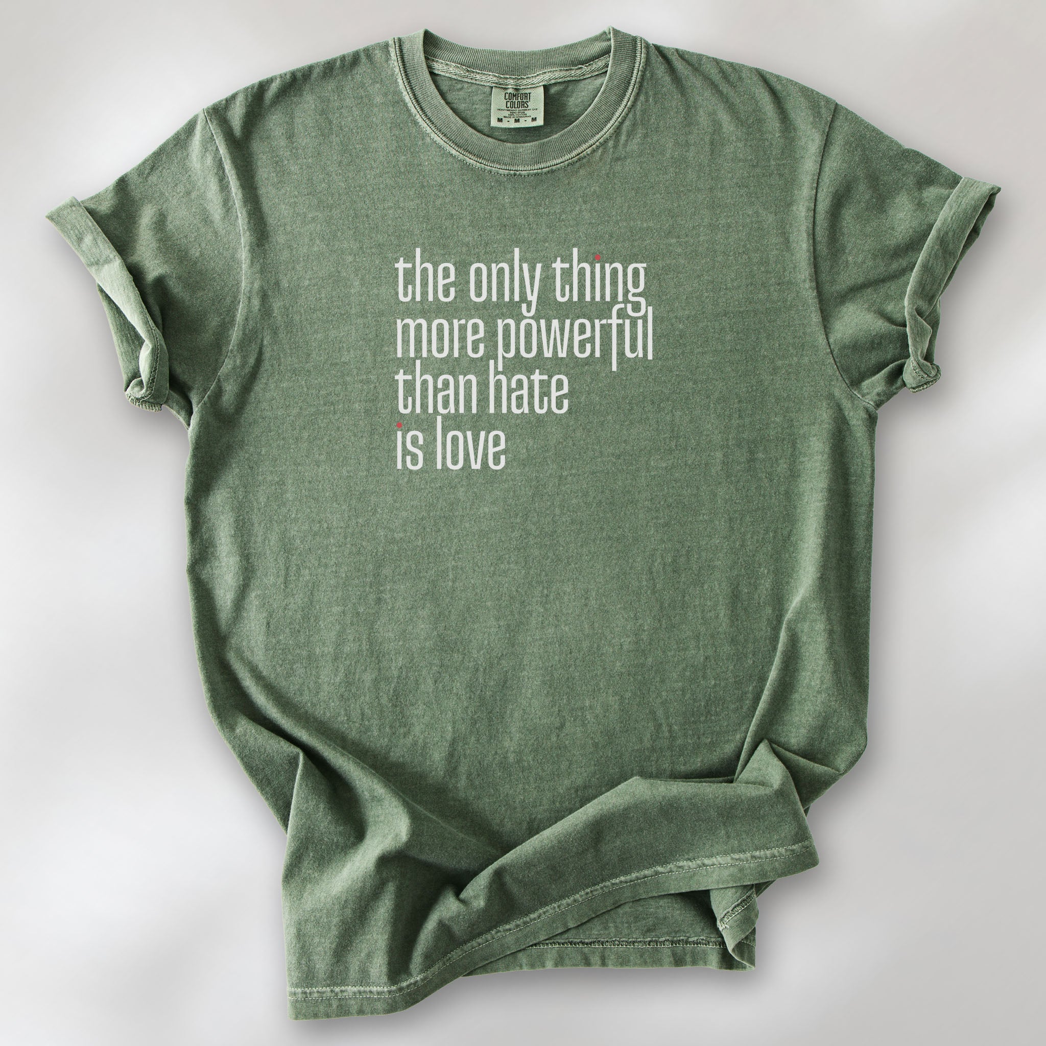 Moss t-shirt with a stylized text block reading “the only thing more powerful than hate is love." 