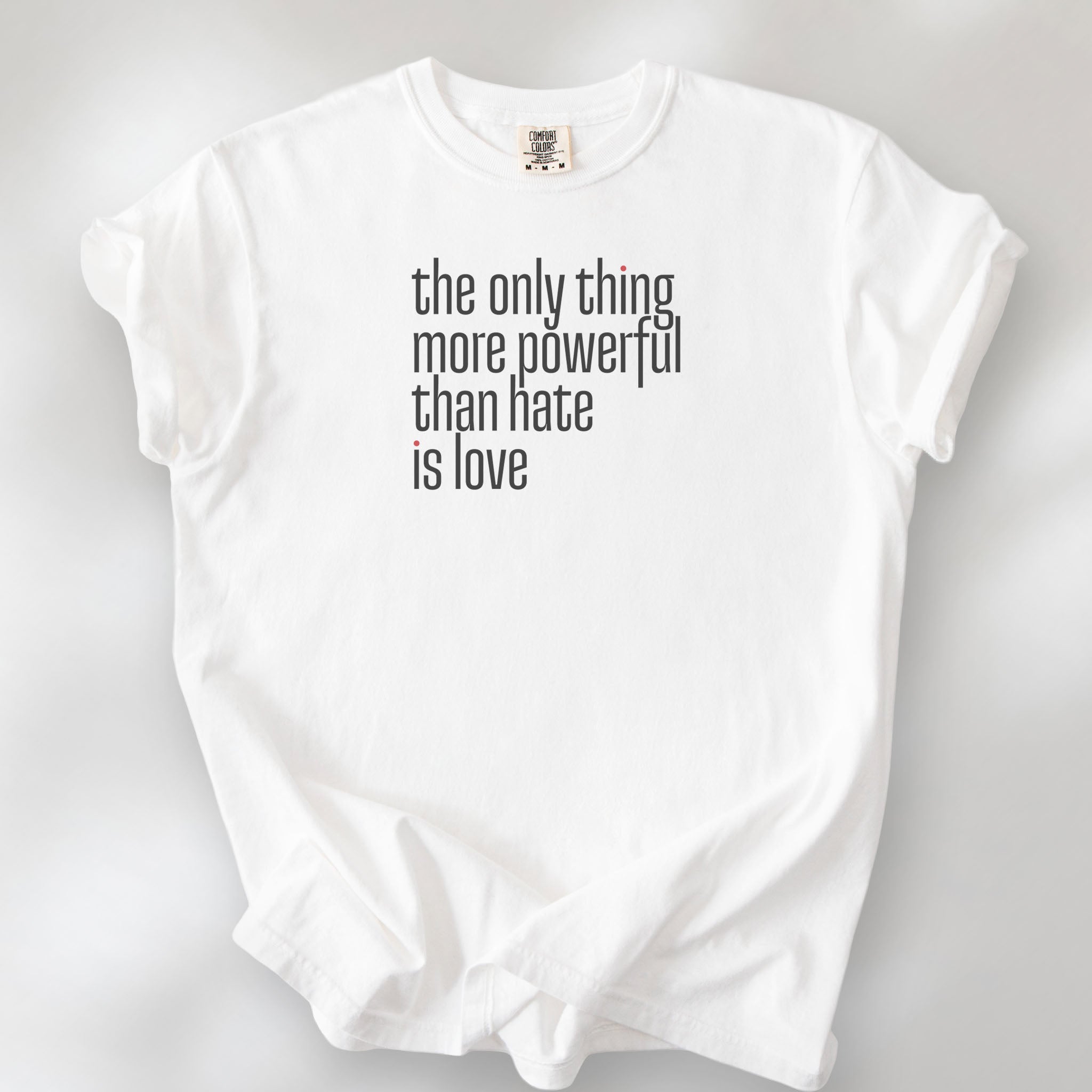 White t-shirt with a stylized text block reading “the only thing more powerful than hate is love."